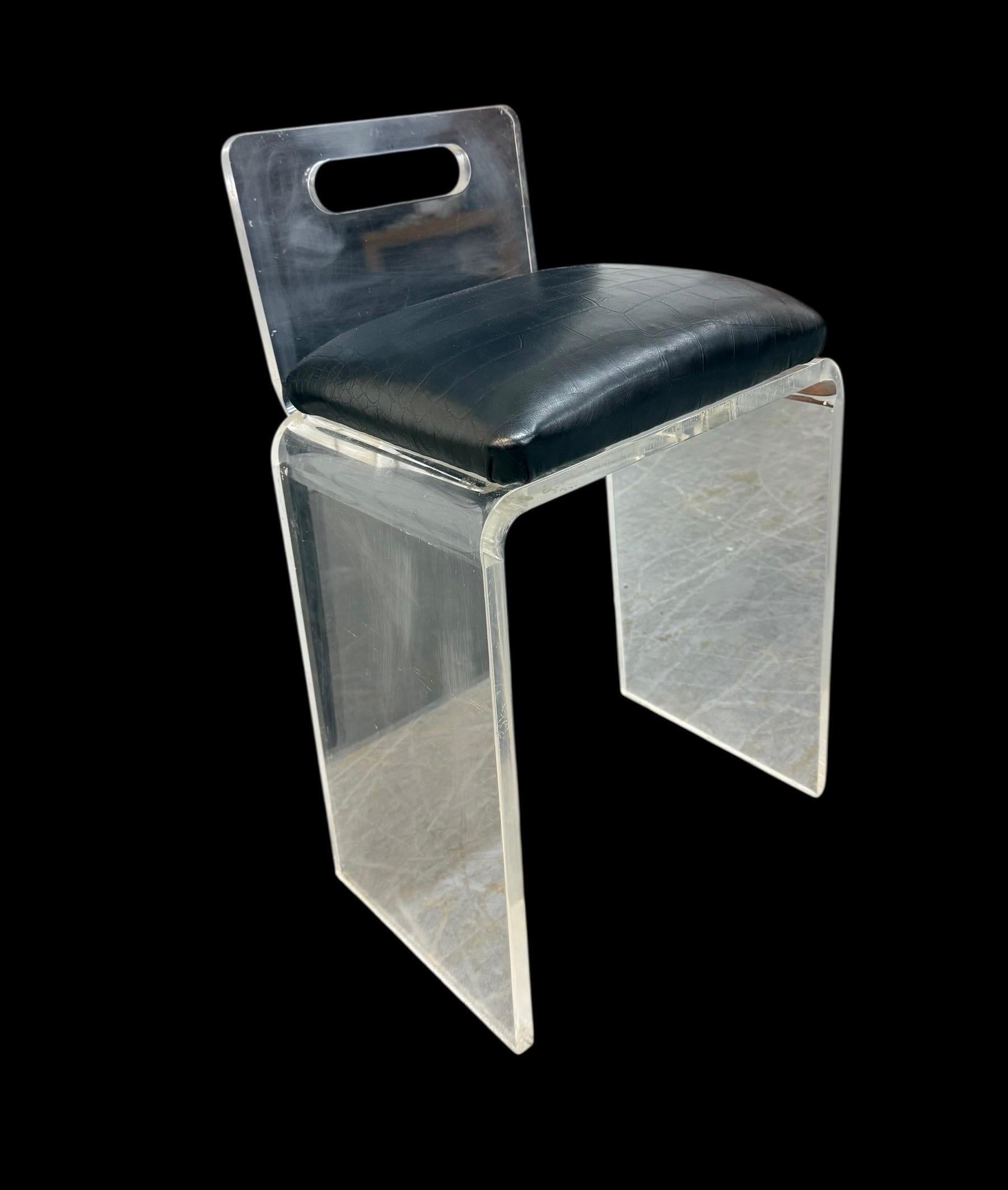 This listing is for a Vintage Lucite Vanity Stool. Featuring a straight line lucite chair base, and new black vinyl upholstery. This is an exceptional combination of quality and vintage design! 