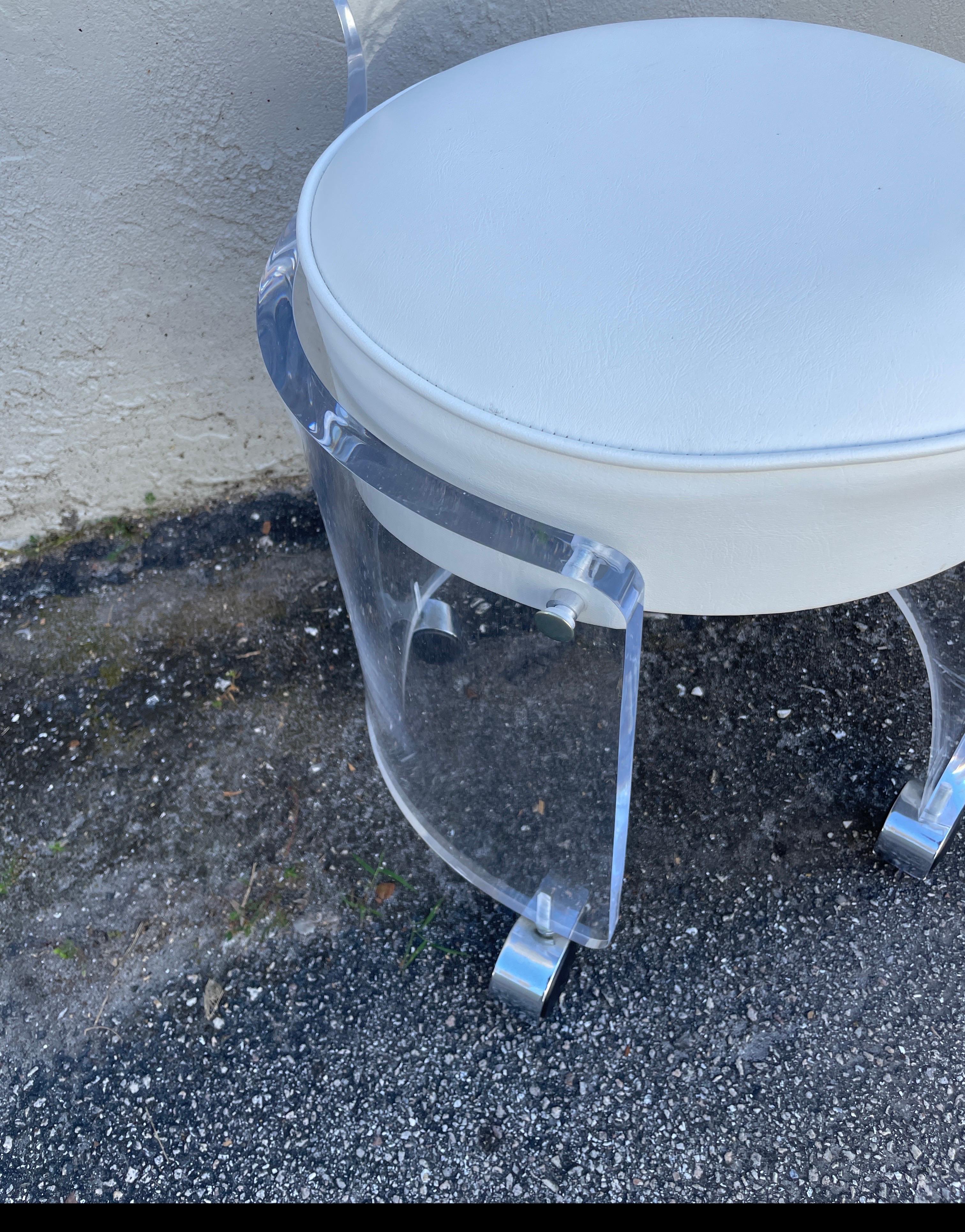 Runder Lucite-Hocker im Hollywood-Regency-Stil mit gebogener Rückenlehne auf Rollen.