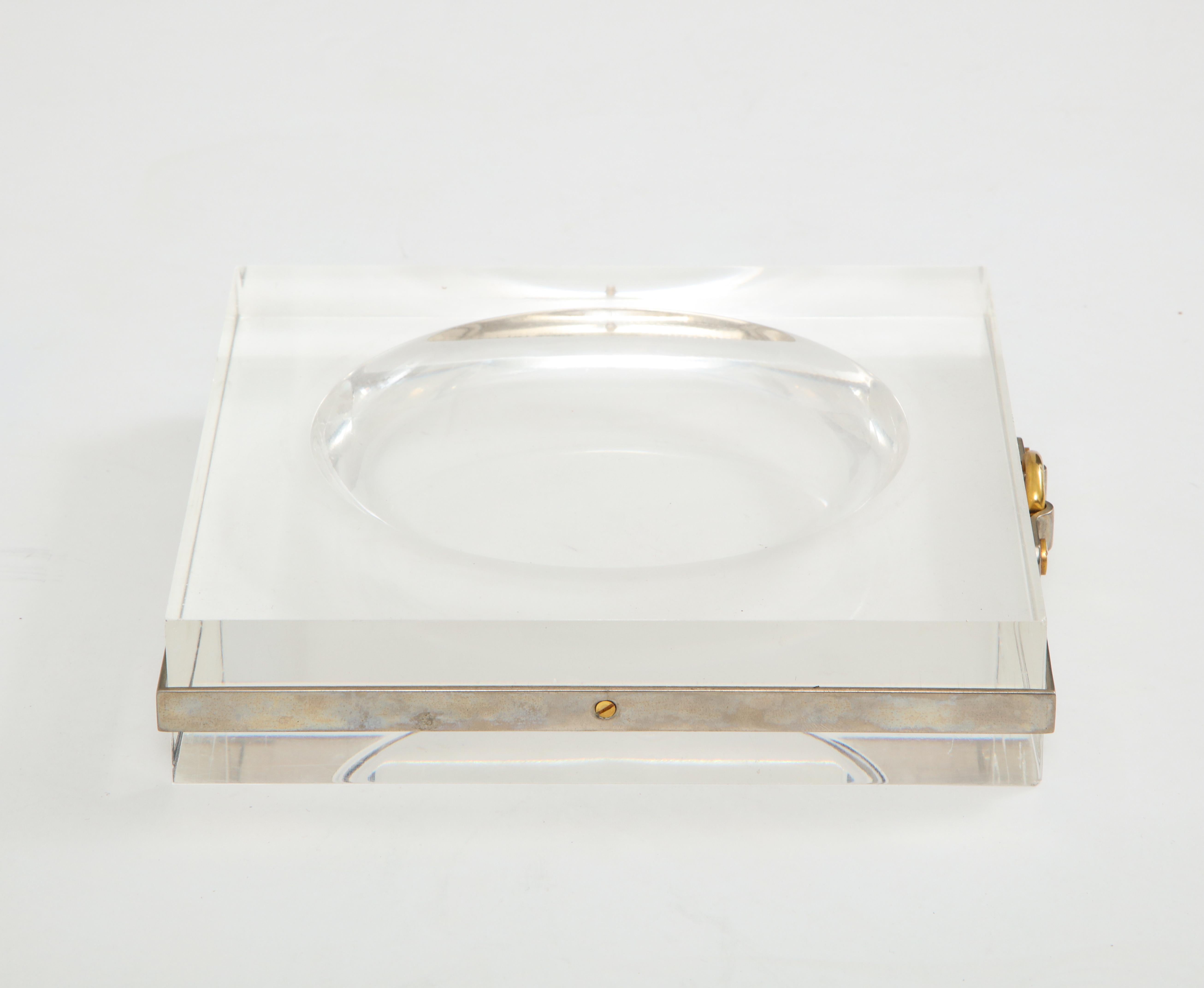 Chic and sophisticated lucite vide poche with nickel band and brass buckle detail, France, 1970s.