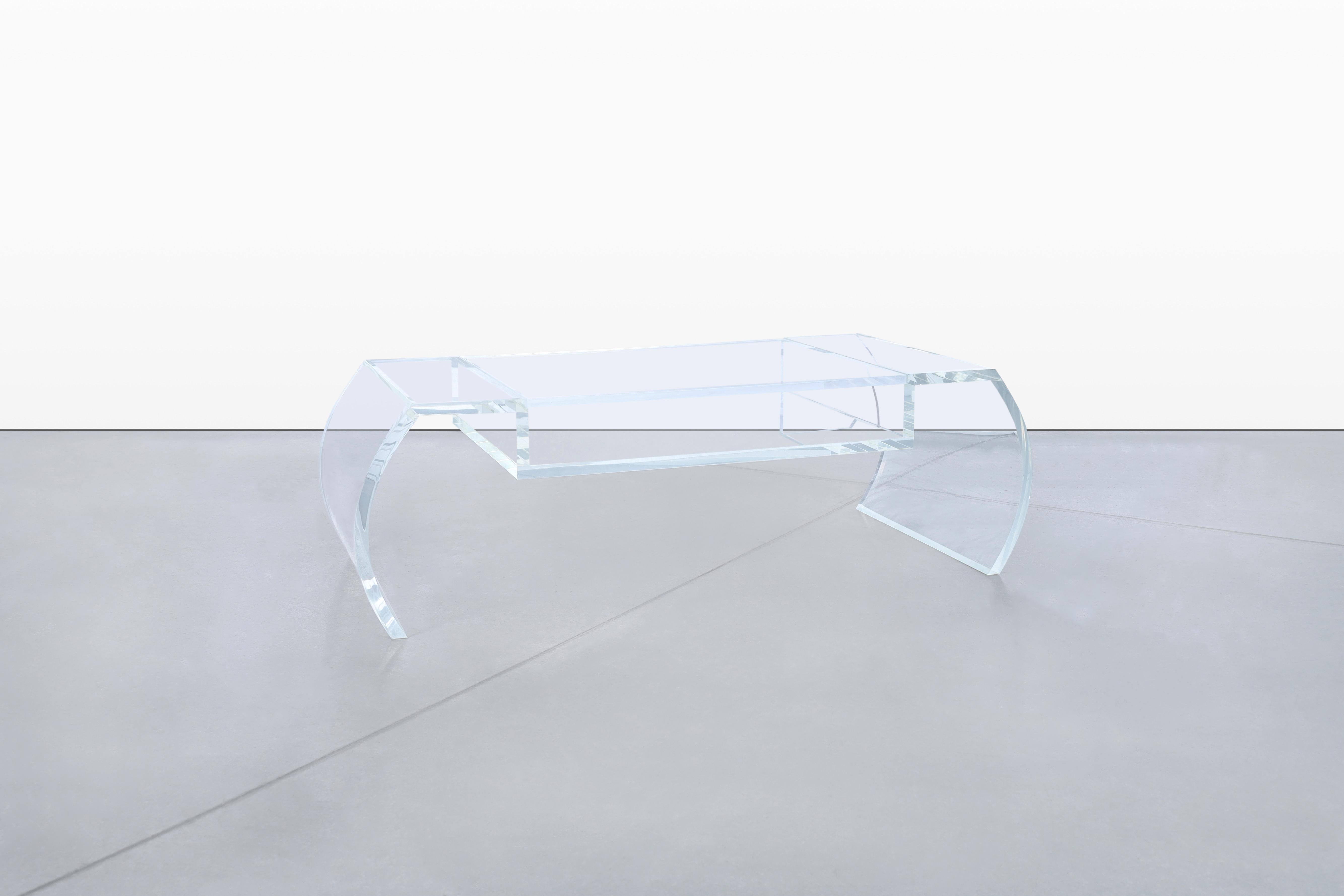 Exemple frappant du design américain des années 1970, cette table basse sculpturale vintage est fabriquée en Lucite cristalline d'une épaisseur exceptionnelle. Définie par ses côtés en cascade, la table présente une silhouette architecturale