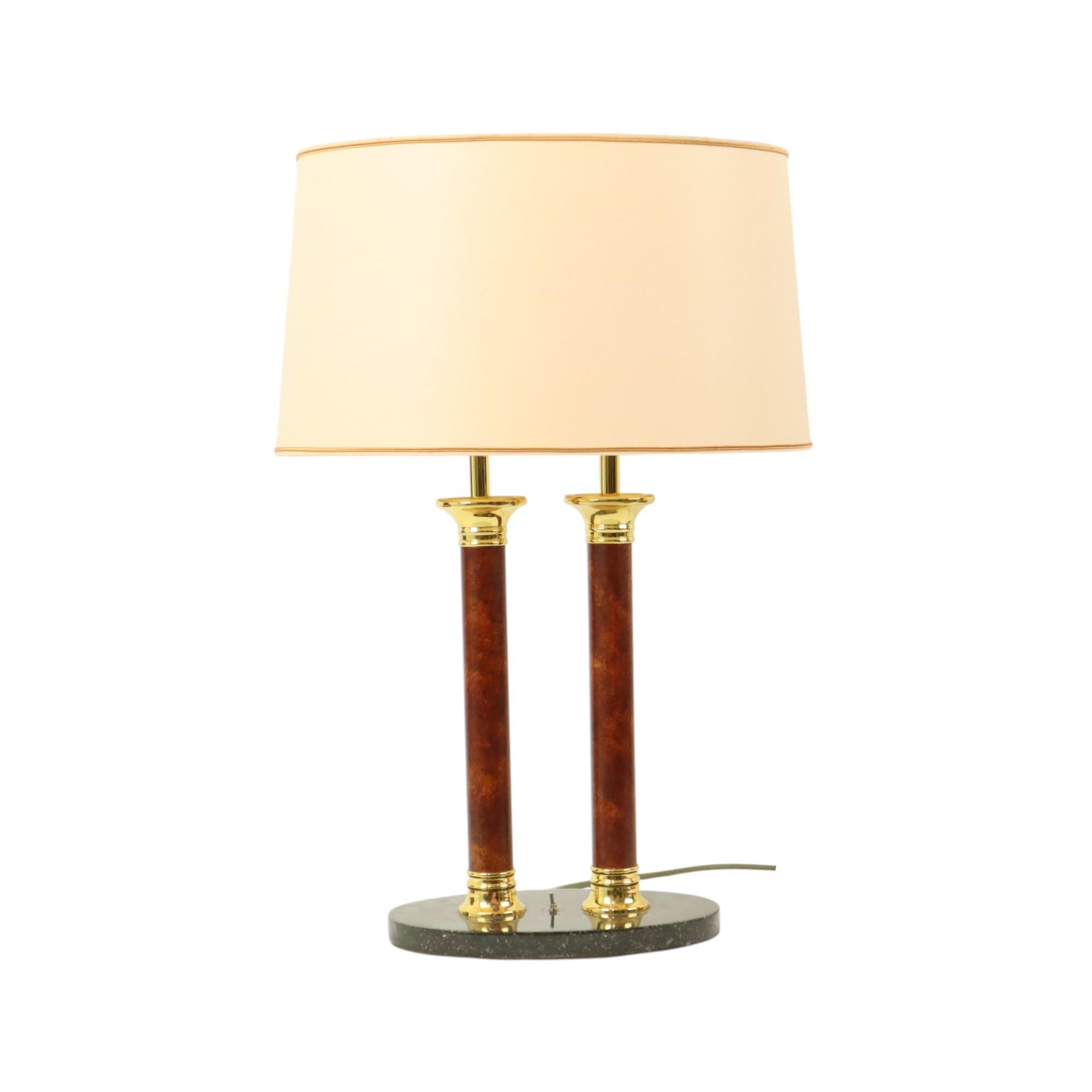 Beautiful table lamp in Hollywood Regency style, an oval marble base, double pillars in faux marble and a double fitting finished with brass, including the original oval lampshade, by Lusterie Deknudt, Belgium, circa 1960s-70s, marked at the bottom