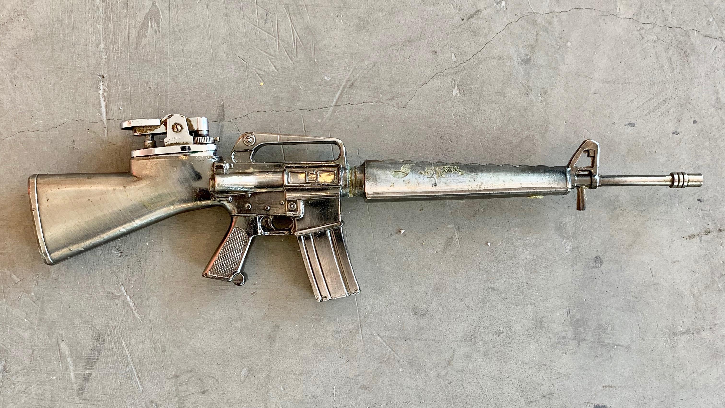 Cool vintage table lighter in the shape of an M-16 rifle. Made of metal in Japan. Good working condition. Great object.

 