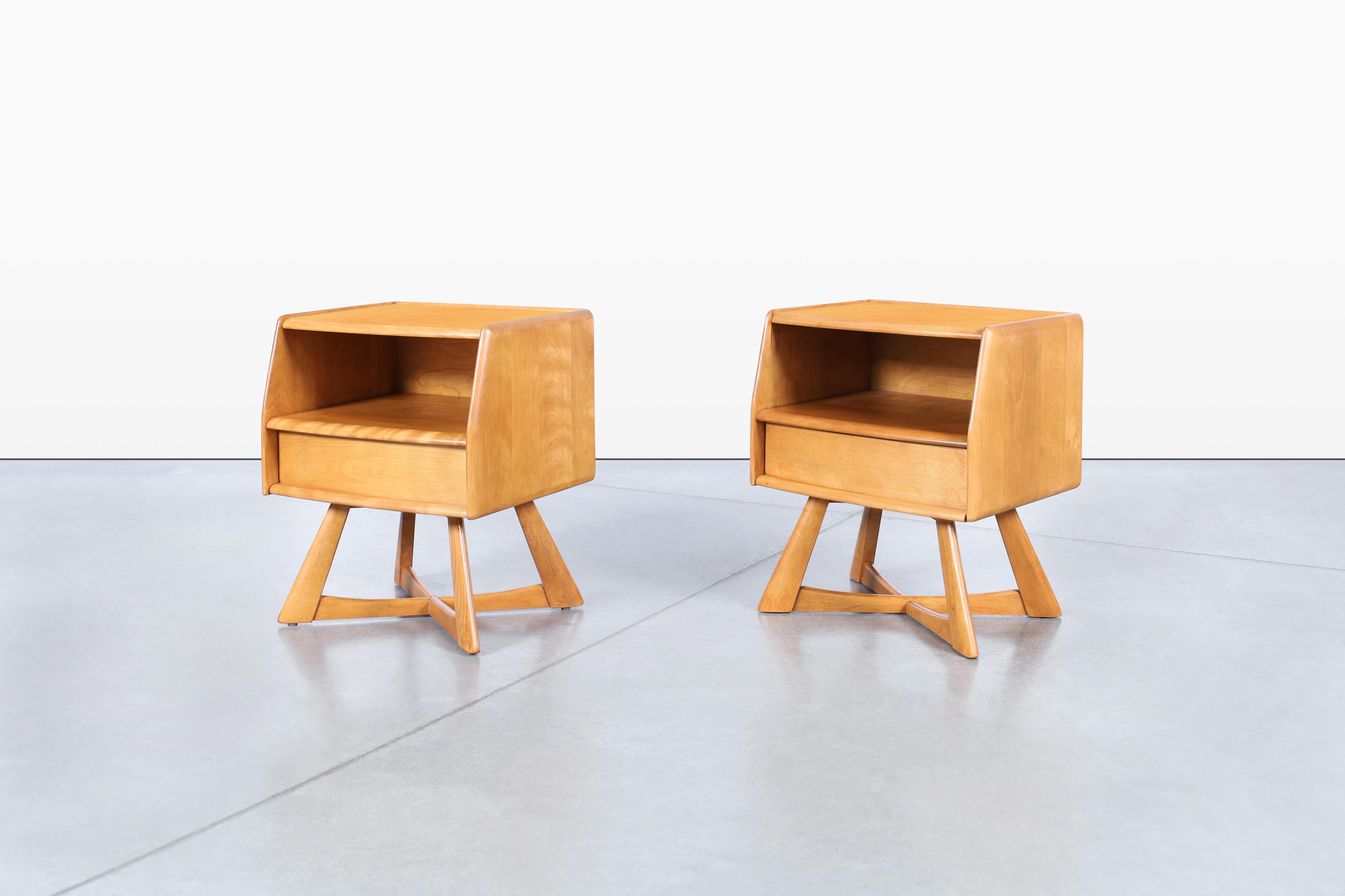 Un hermoso par de mesillas de noche vintage diseñadas por Heywood Wakefield en la década de 1950. Conocidas como M-778, estas piezas encarnan la calidad artesanal y el diseño atemporal por los que la marca es célebre. Fabricadas con madera maciza de