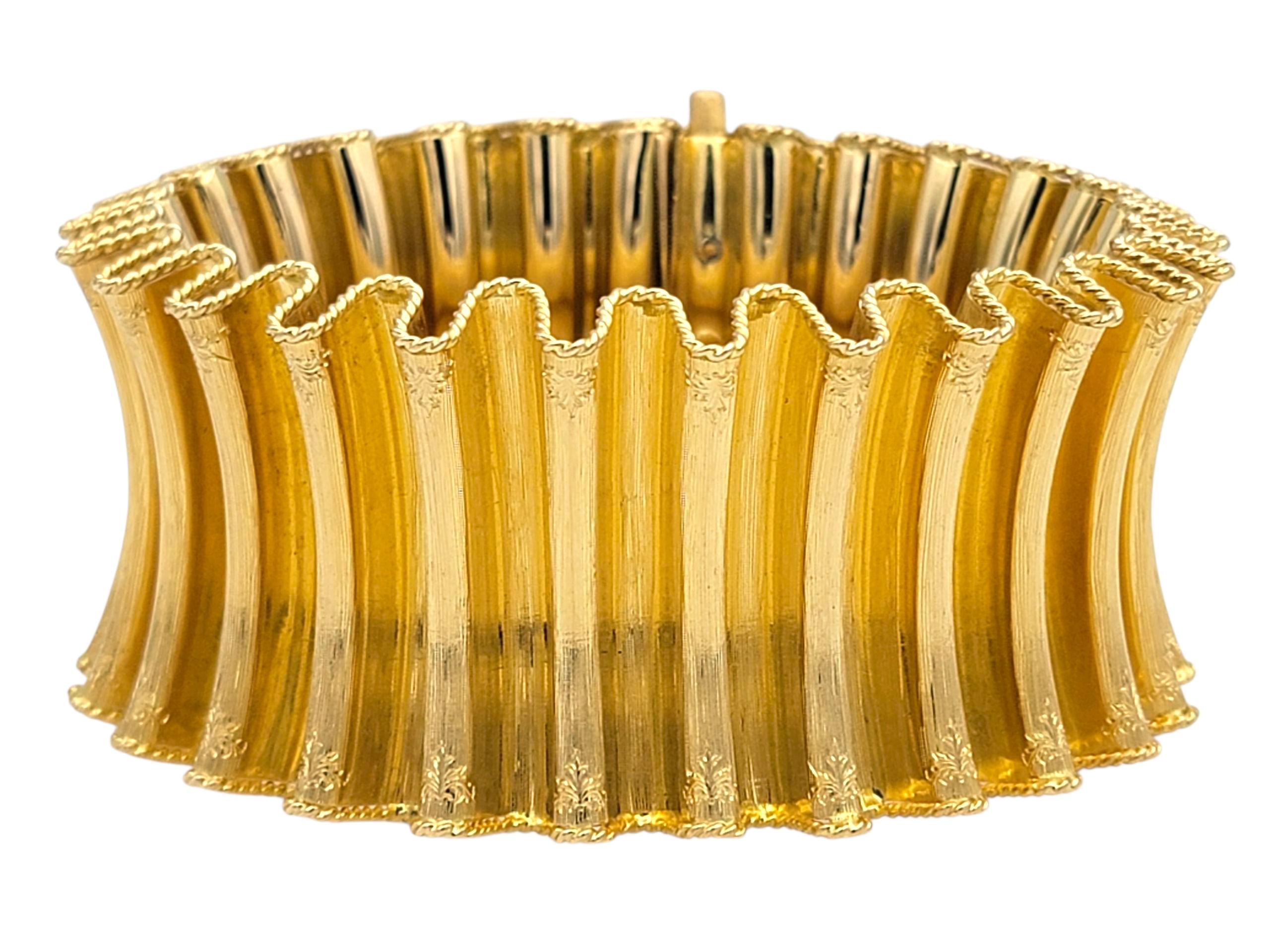 Cet authentique bracelet manchette vintage de M-One est réalisé avec brio en or jaune 18 carats, mettant en valeur les textures artistiques renommées de la marque. Le design large et audacieux présente des panneaux ondulés et sculptés avec une