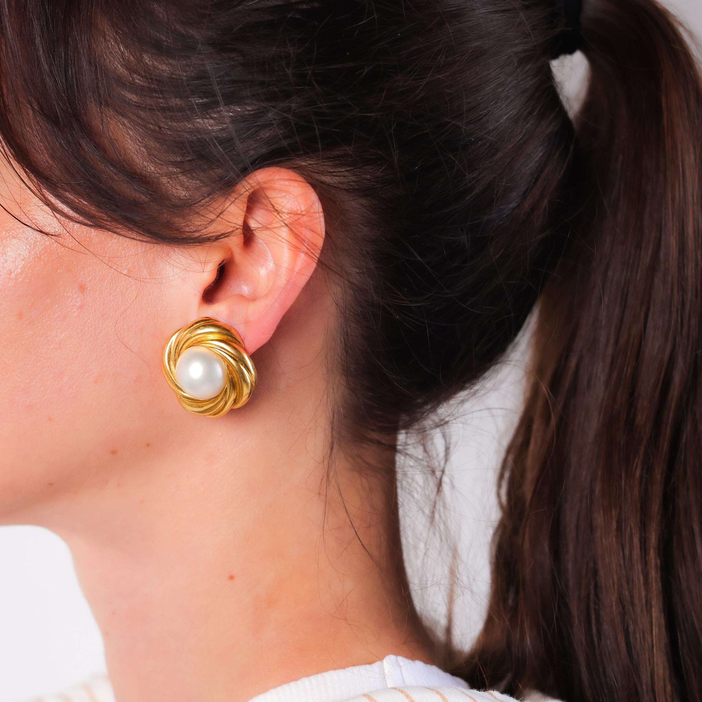 Center Stone: 2 Mabe Pearls
Size: Approximately 15.88mm and 16.06mm
Metal: 18K Yellow Gold
Era: Vintage
Circa: 1980's
Hallmarks: Makers Marks
Size: 1.25 x 1.25 inches
Gram weight: 27.82

These elegant vintage clip-on earrings feature two stunning