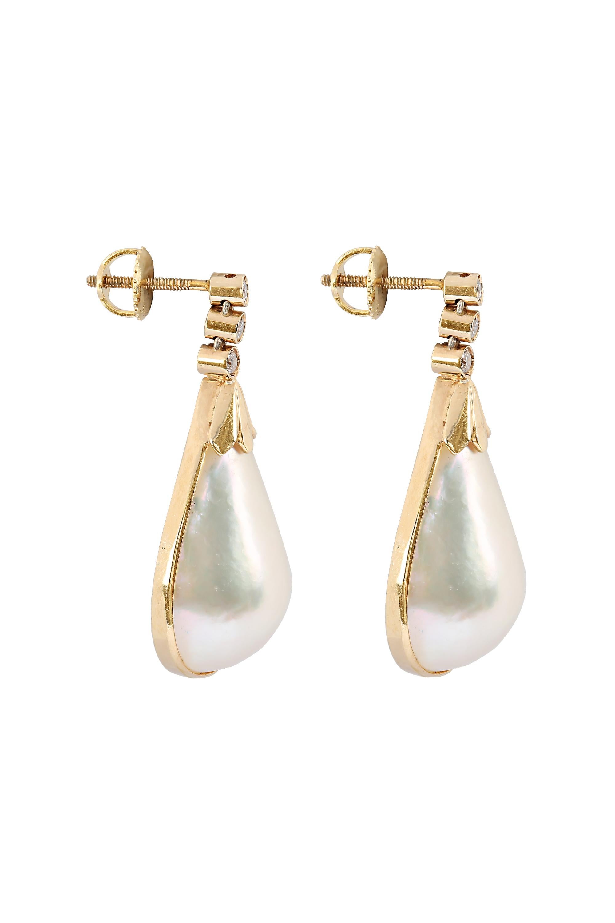 Graceful pear shaped drops of lustrous Mabé pearl are suspended from three bezel set diamonds to create a lovely and polished pair of earrings. Fabricated in 14-karat yellow gold with secure threaded posts and set with approximately .20 carats of