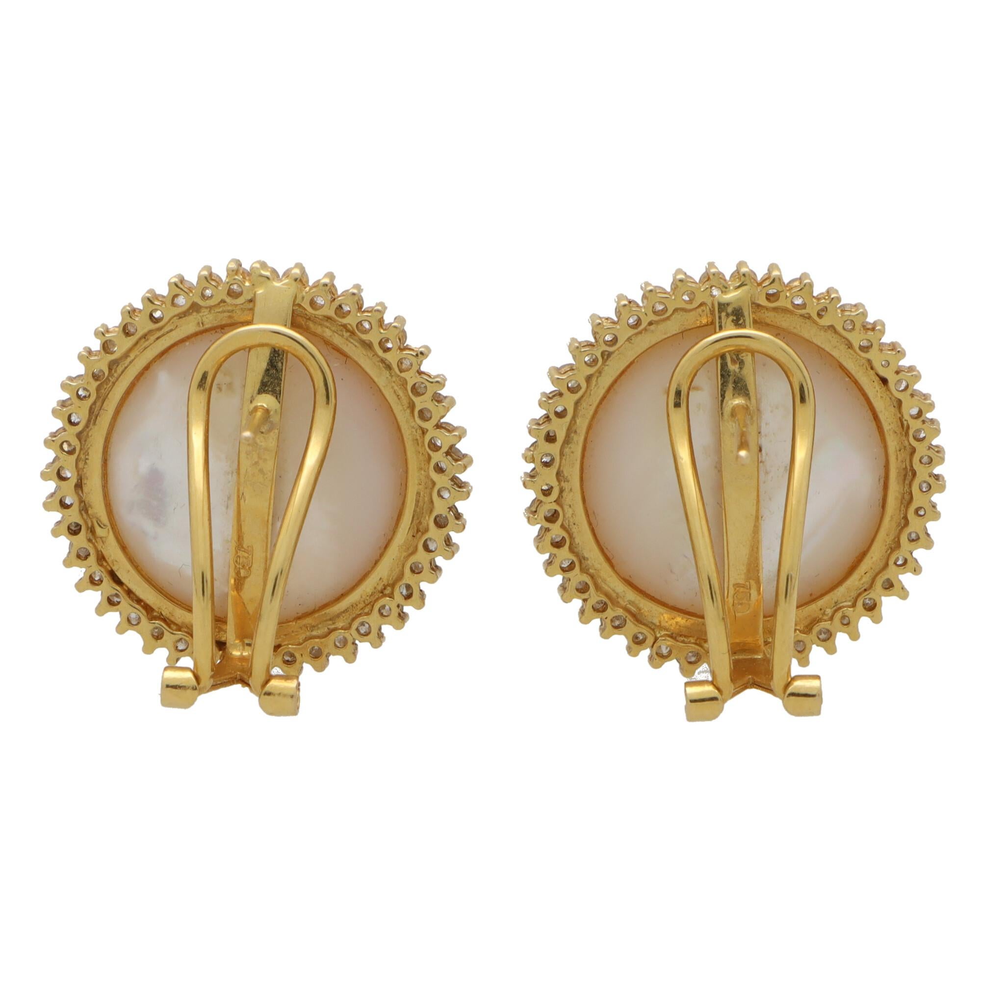 A beautiful pair of vintage Mabe pearl and diamond earrings set in 18k yellow gold. 

Each earring is centrally set with a lustrous 17-millimetre Mabe pearl surrounded by an elegant halo of 43 round brilliant cut diamonds. The earrings are secured