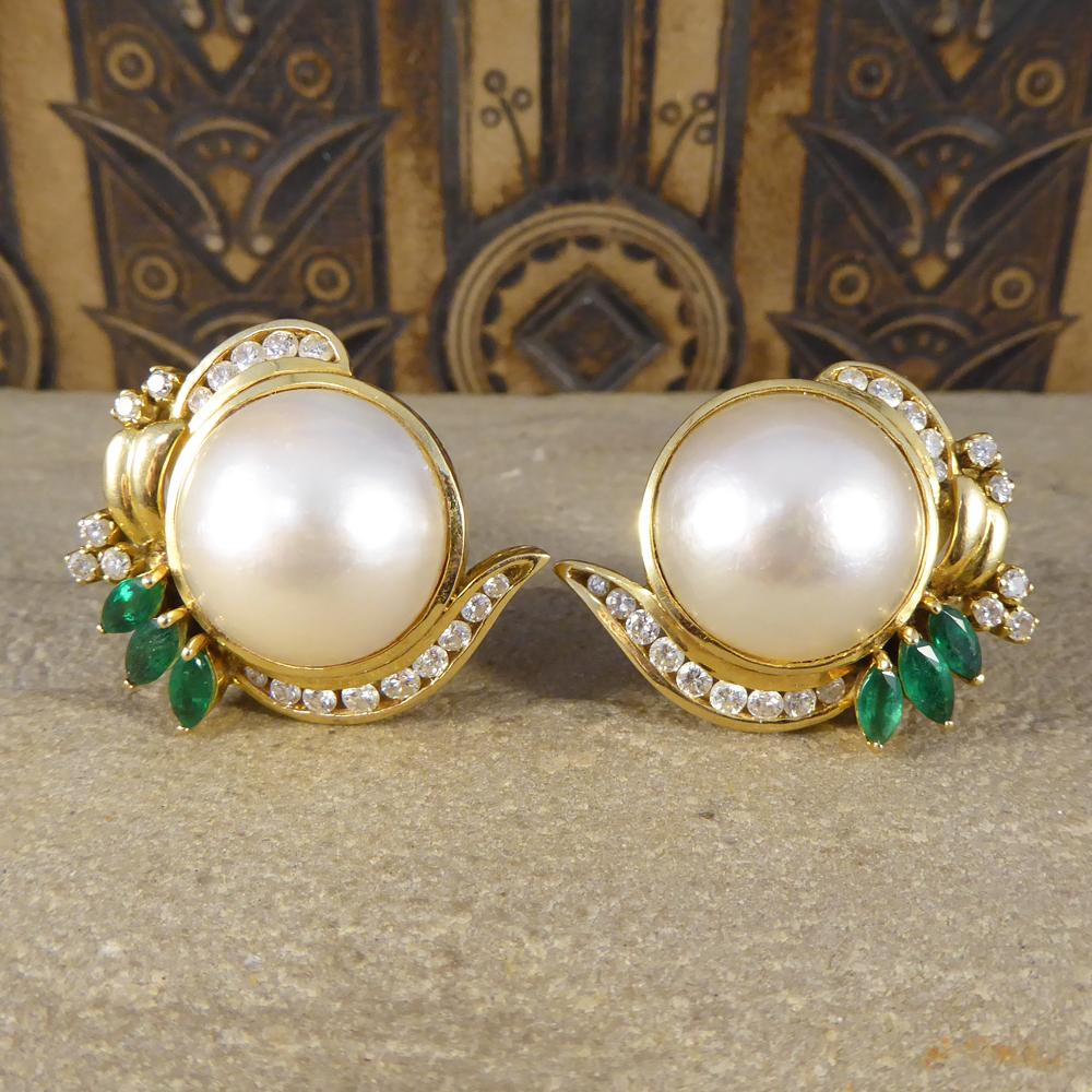 In each of these large stand out earrings sits a single Mabe Pearl, adorned with Round Cut Diamonds and Marquise Cut Emerald creating great detailing around the Mabe Pearl. These vintage earrings have been crafted in 18ct Yellow Gold with a