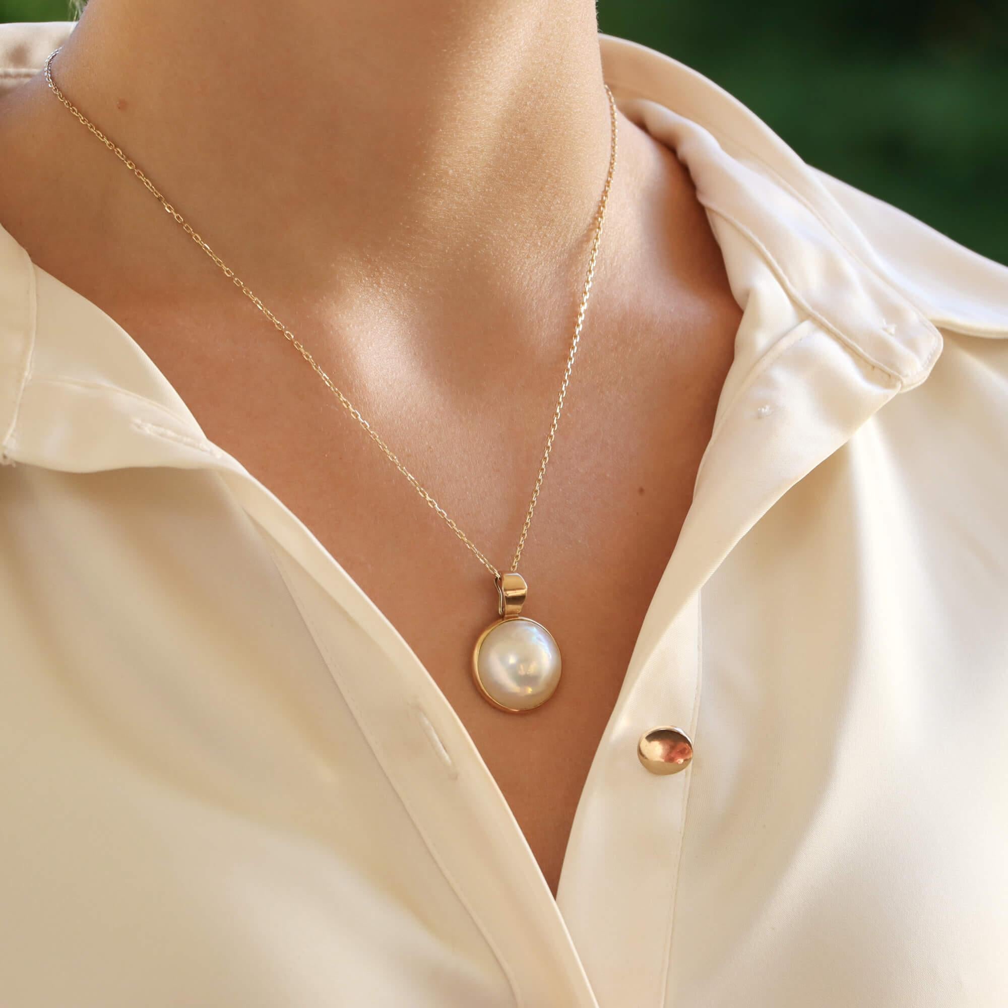  A beautiful vintage Mabe pearl pendant set in 9k yellow gold.

The pendant is predominantly set with a lustrous 17-millimetre Mabe pearl encased in a rubover yellow gold setting.

Due to the design and size this pendant could be worn for a variety