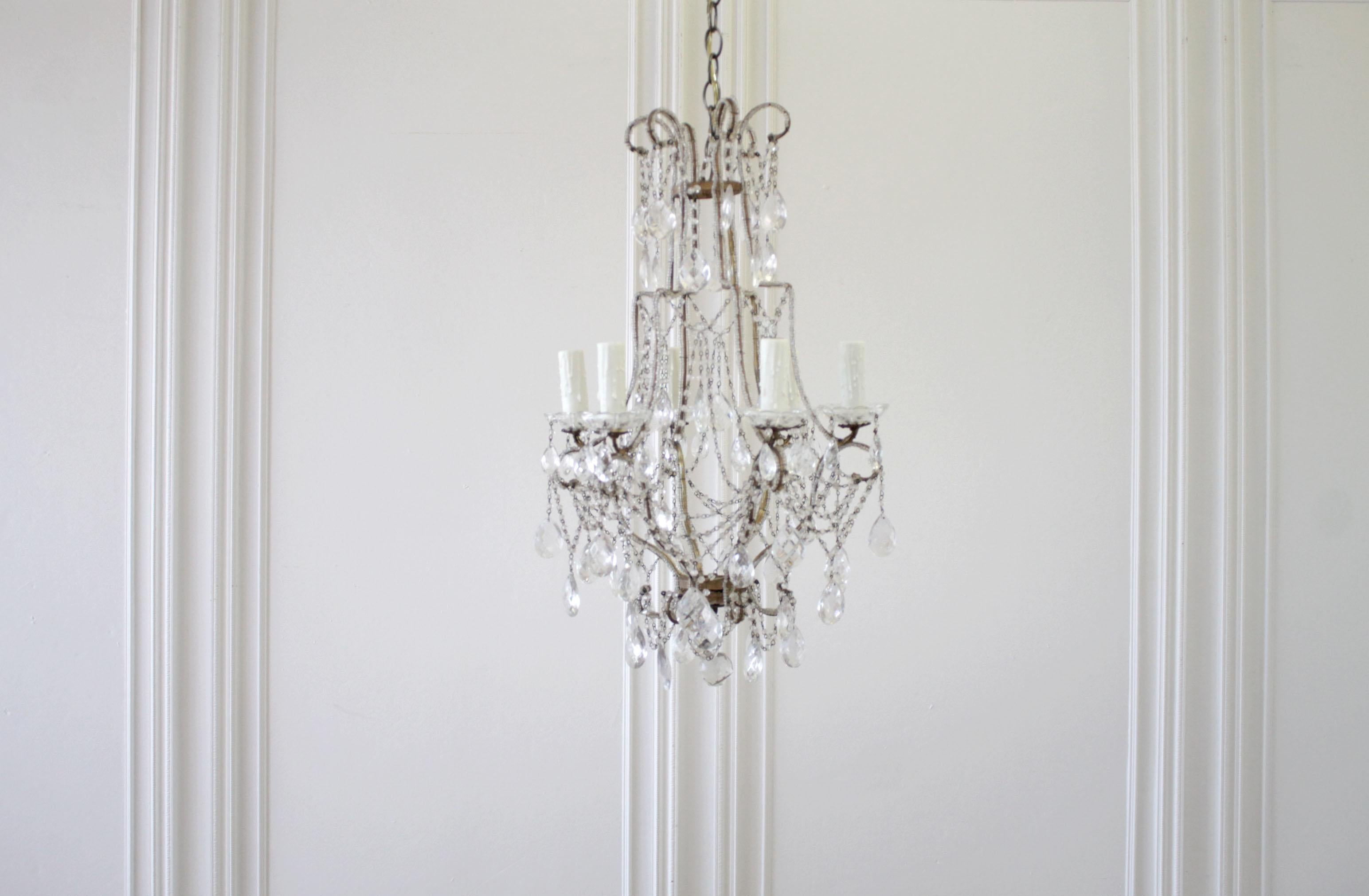 1940s Italian gilt iron chandelier consisting of a crystal beaded gilt iron frame with faceted prisms and 