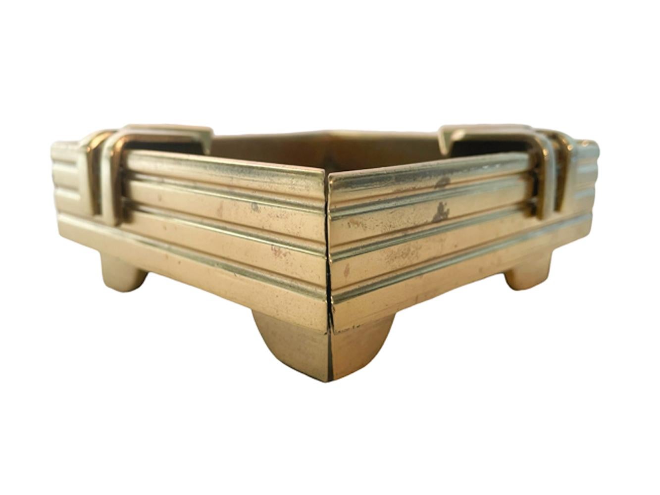 Square bronze ashtray of architectural form with mitered corners and nickel rivets. The square bowl with ribbed sides raised on inset feet, two cigar rests clip onto opposing corners. The modernist style of this piece suggests Bauhaus architecture