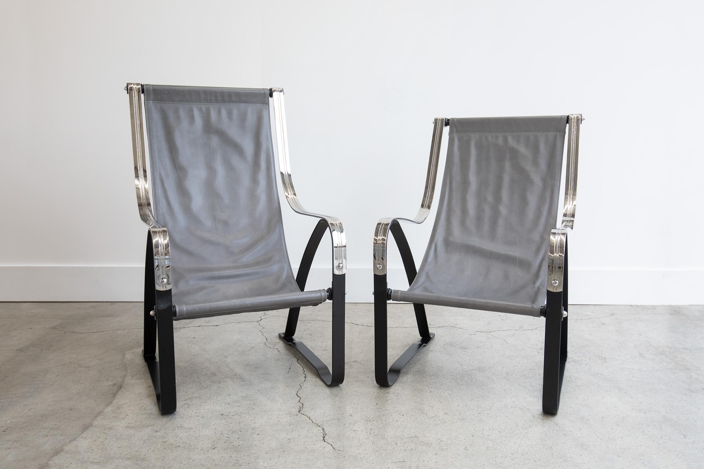 Gorgeous pair of Art Deco, Machine Age leather sling chairs by Salvatore Bevelacqua for McKay Craft Furniture Company. Featuring impressive chromium plated steel arms, iron base, and leather slings. This pair is a 