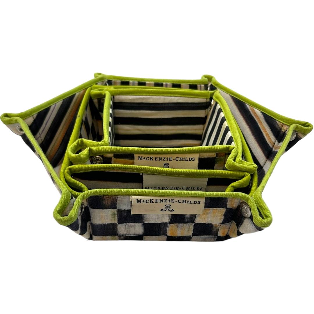 These vintage MacKenzie-Childs storage baskets are a charming addition to any collection.  Featuring a unique “Courtly Check” pattern and made of durable fabric, these snap-closure baskets are perfect for storing small items or serving as a valet
