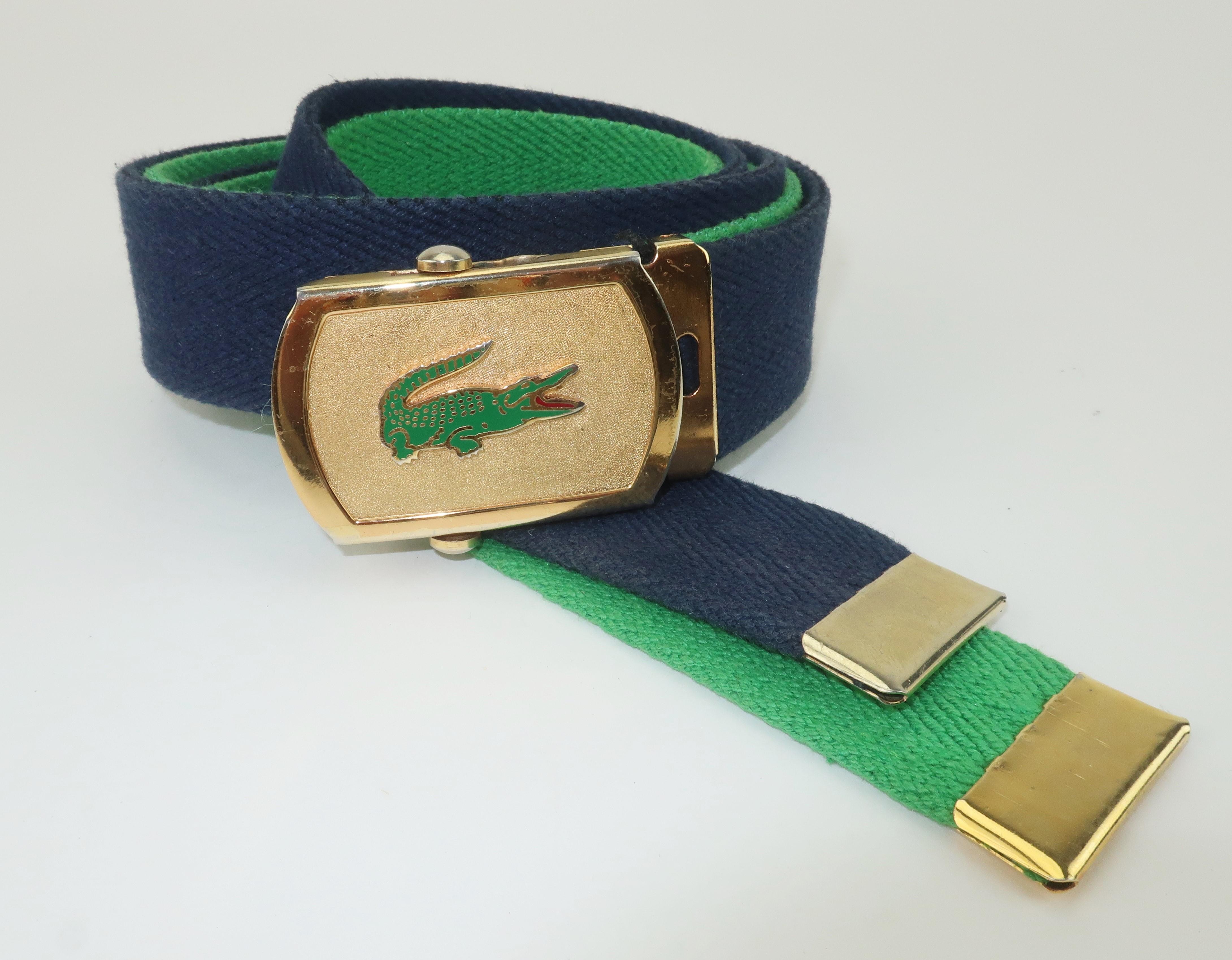An alligator that never goes out of style!  A classic preppy look from the iconic brand, Izod Lacoste, consisting of an Italian made gold tone buckle and two belts in navy blue and green.  The slide buckle mechanism and clamp make for an easy quick