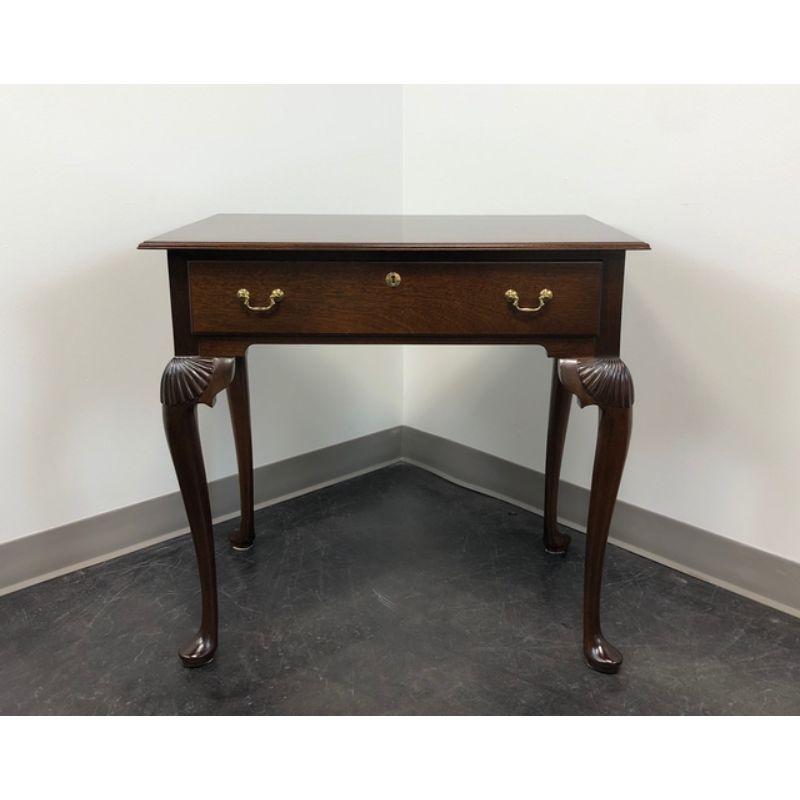 An accent table by Madison Square, of Hanover, Pennsylvania, USA. Solid mahogany with brass hardware, shell carved knees, cabriole legs and pad feet. Features one drawer of dovetail construction with faux lockplate. Made in the late 20th Century.