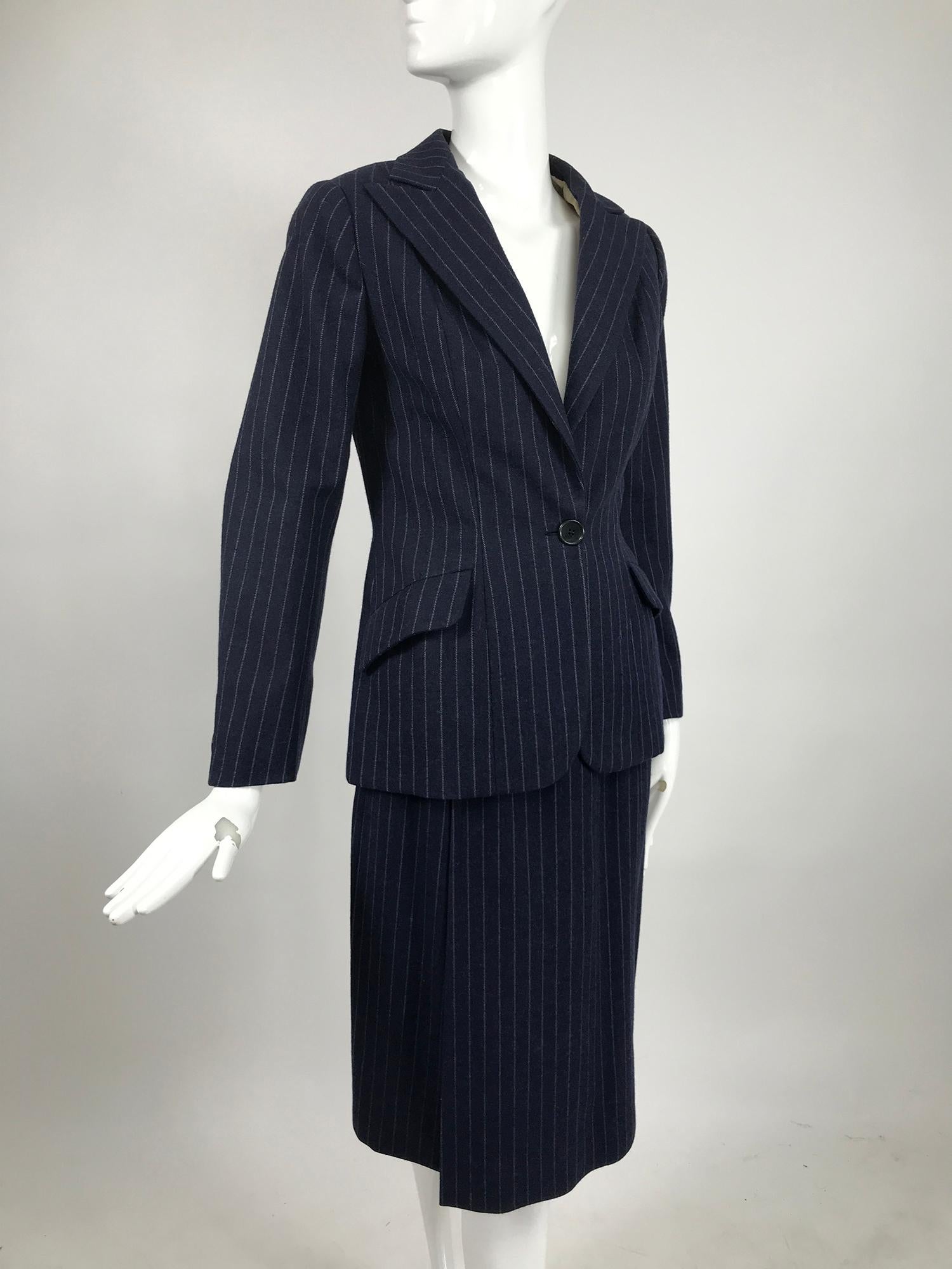 Combinaison vintage Maggy Rouff Couture en laine à rayures en bleu militaire et gris, du début des années 1950. Veste croisée se fermant par un seul bouton à la taille, revers crantés, poches de travail à rabat incliné, buste à pinces, taille
