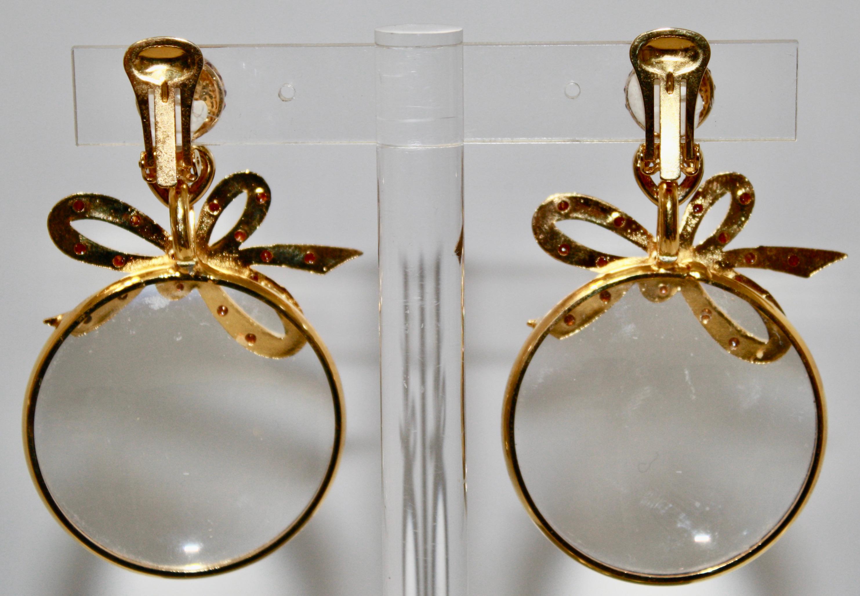 Statement earring in gilded metal of Vintage origin. Made in the 1980s with a bow motif reminiscent of Chanel. Round loupe is circled in gold
