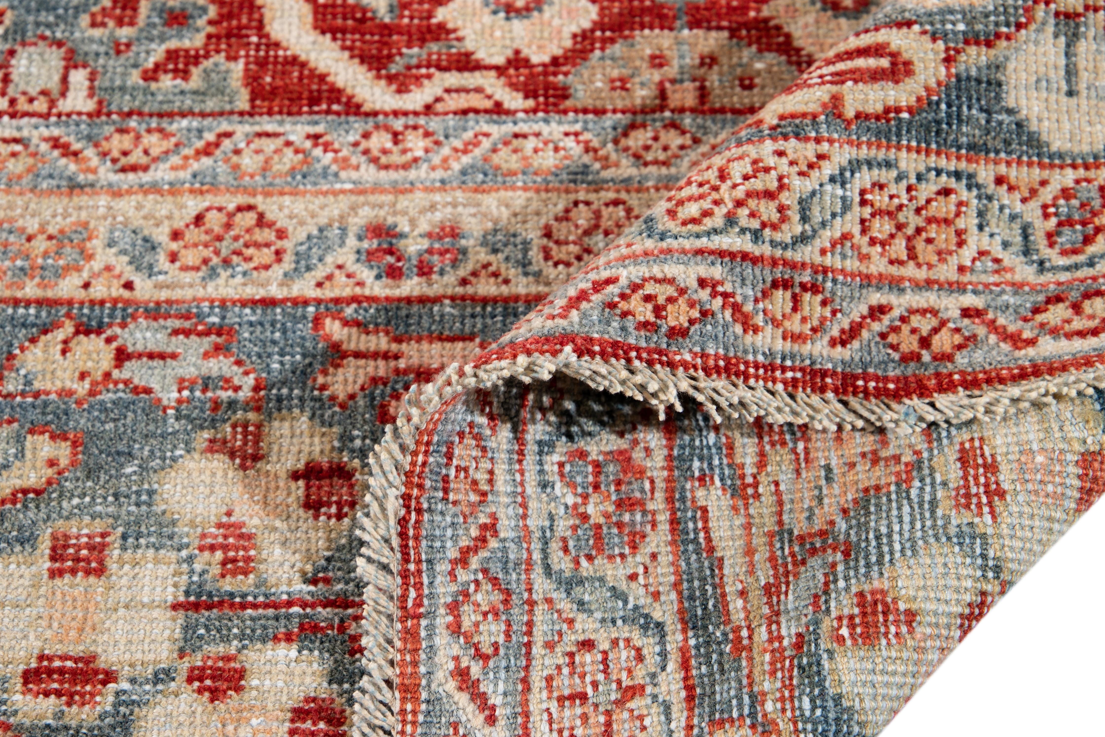 Beautiful Vintage Mahal hand knotted wool rug with a red field. This rug has blue, beige, and peach accents in a gorgeous all-over geometric floral medallion design. 

This rug measures 9' 2