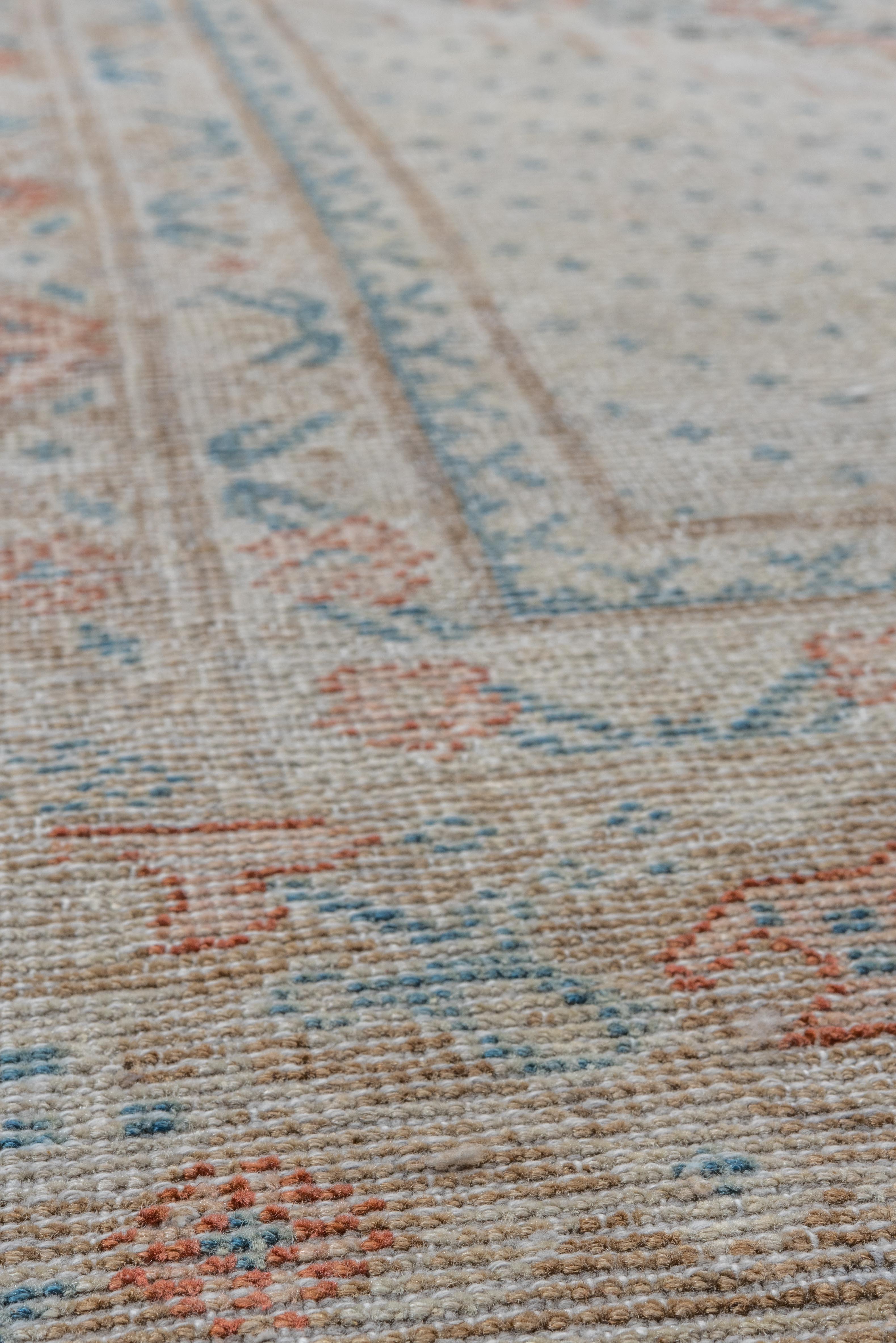 This vintage Mahal rug offers a serene interpretation of Persian classicism, featuring a gently worn medallion design in soft powder blue, blush, and ivory tones. The field is composed of intricate floral latticework and stylized vines, all rendered
