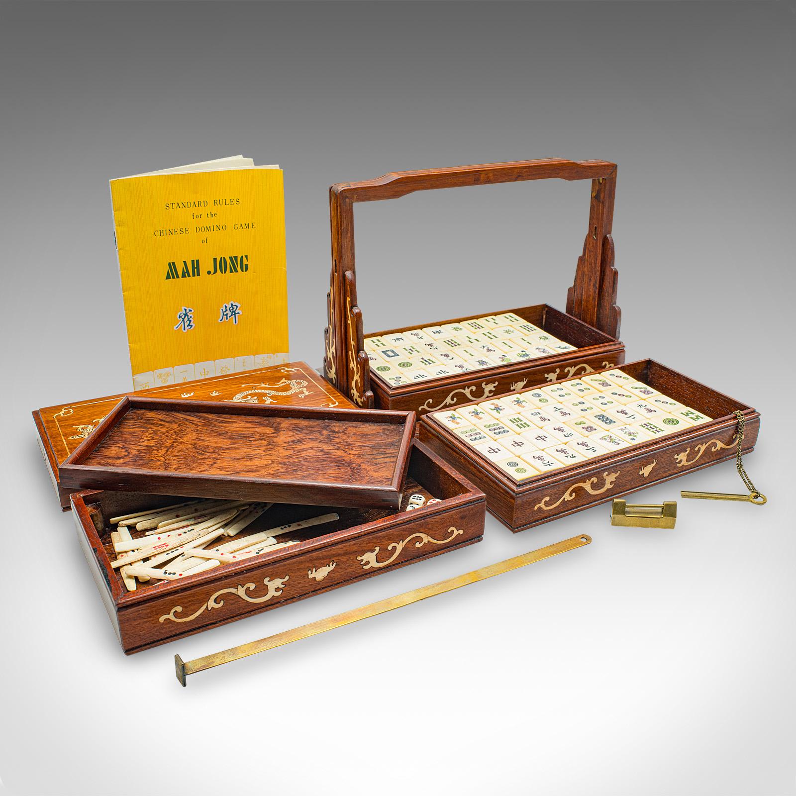 Il s'agit d'une mallette de Mahjong vintage. Ensemble de jeu chinois en acajou et celluloïd, datant du milieu du 20e siècle, vers 1950.

Fascinant étui de fermeture, rappelant une carafe Tantalus
Présente une patine d'usage désirable et est en bon