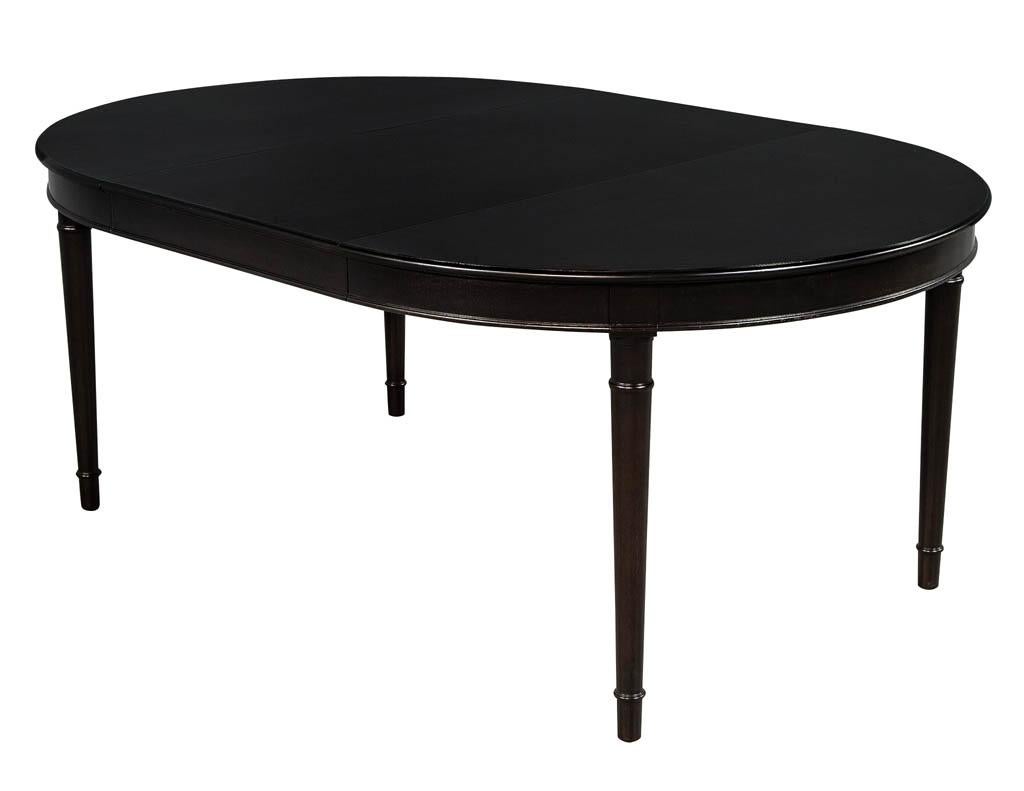 Vintage mahogany ebonized black dining table. American made, circa 1940s. Recently finished in a rich satin black lacquer. With a Classic clean design, includes 1 extension leaf.

Measures: 49.5” diameter (closed) and has 1 x 24” leaf extensions
