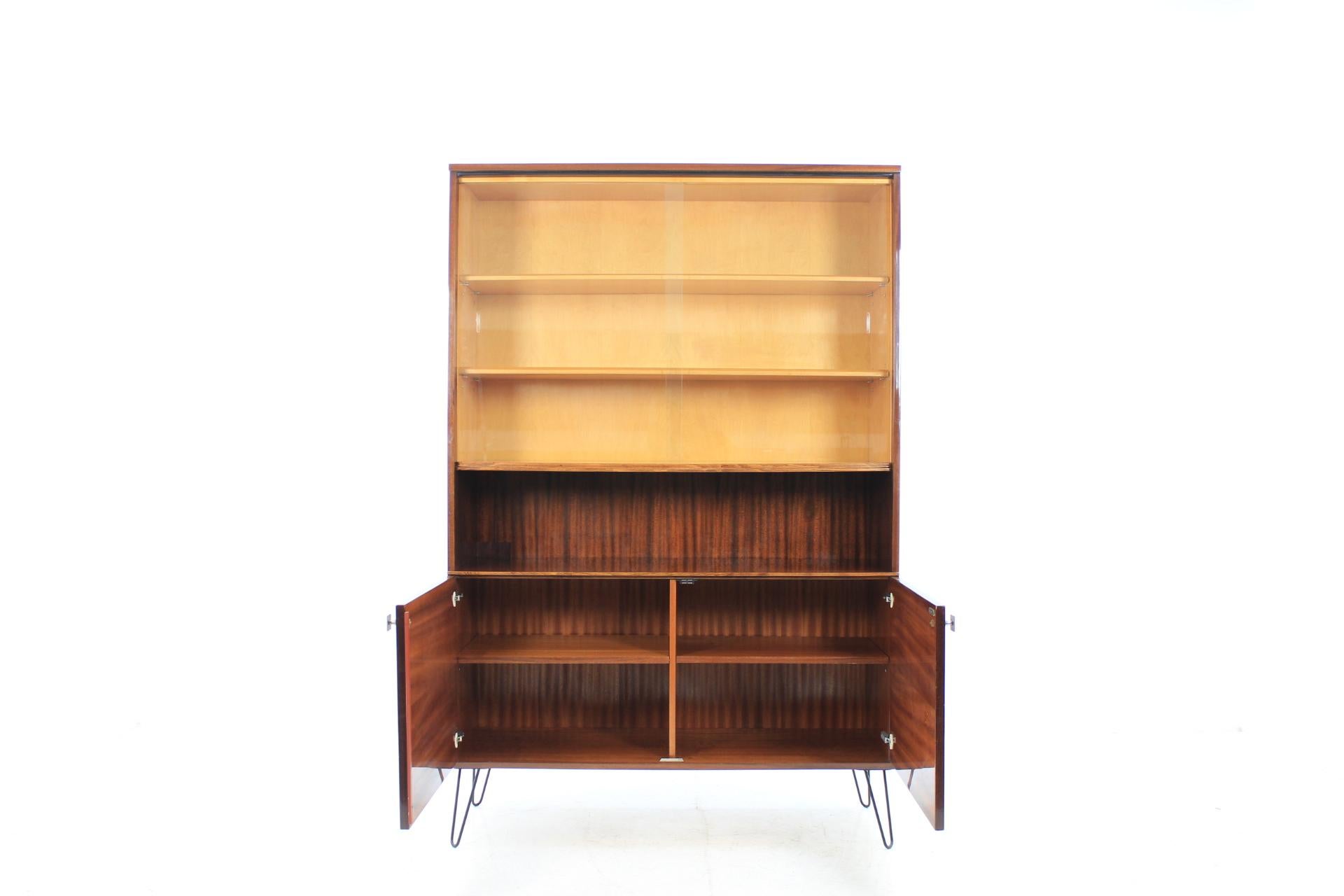 Bookcase made of mahogany and glass. The item made from Interier Praha in Czechoslovakia. The iron legs were added afterwards. Original condition.