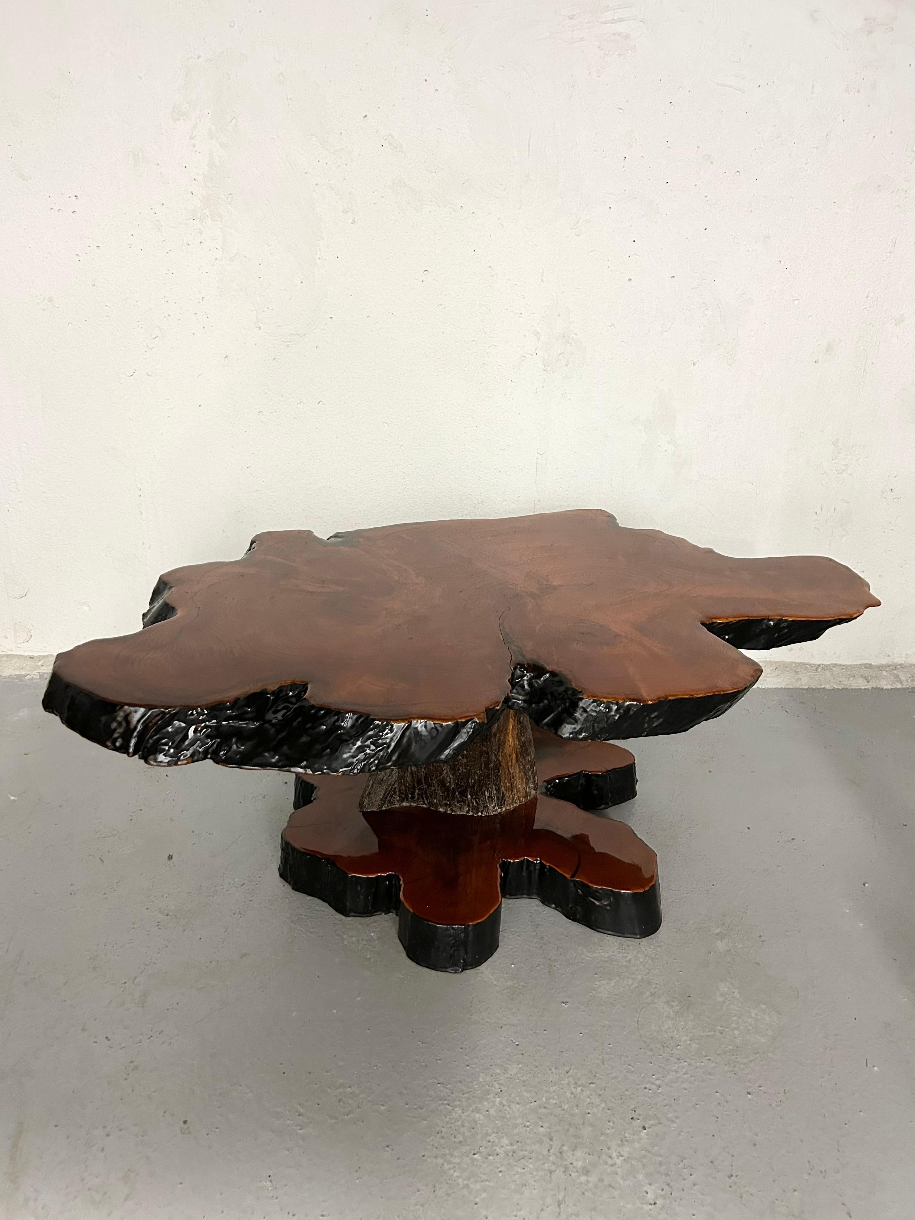 Vintage live edge burl wood coffee table made from mahogany. Edges of top and bottom base are painted black. Surfaces and edges are sealed with lacquer. Minimal wear. The table top has normal surface wear. There is one small crack in the lacquer on