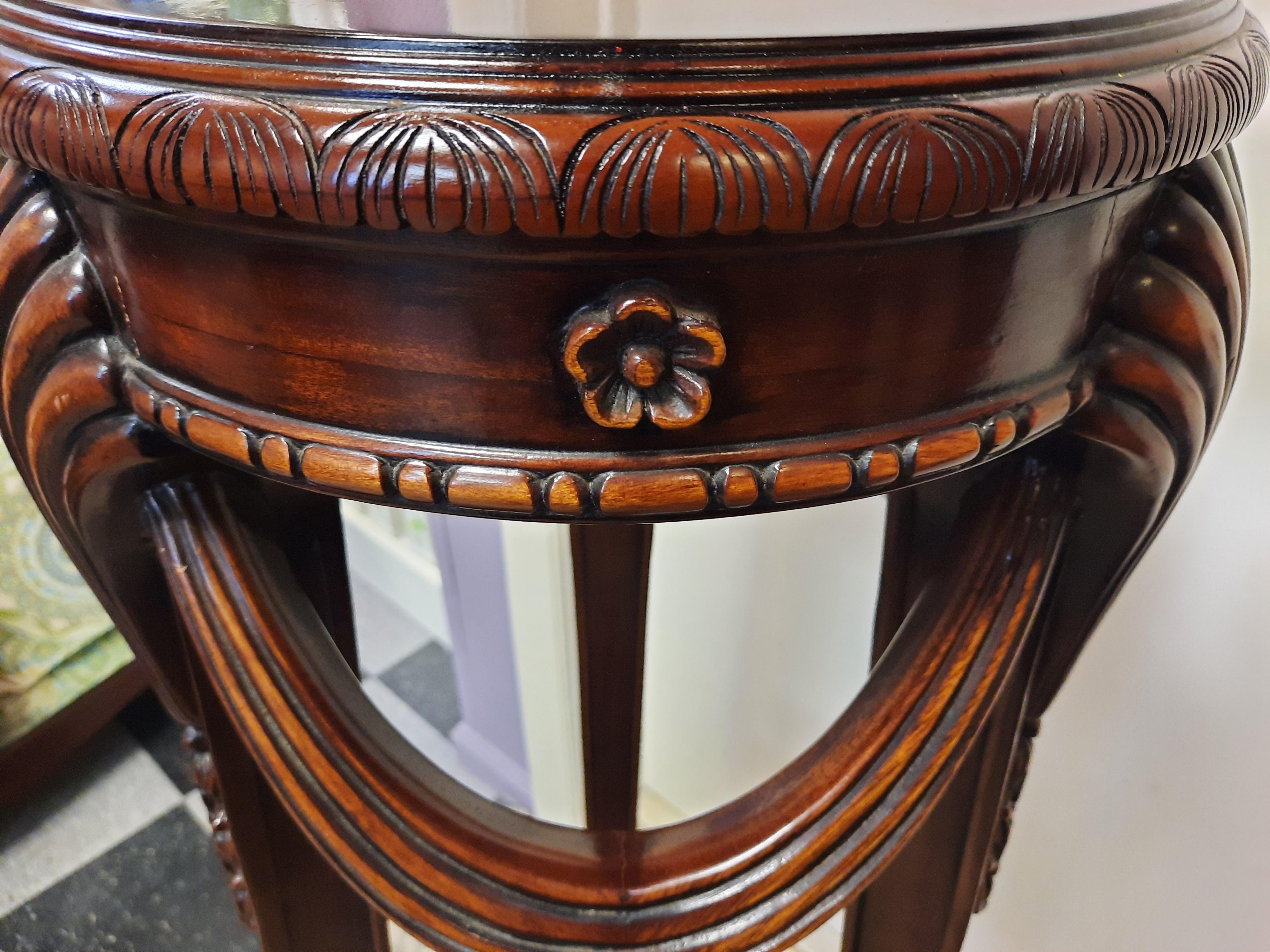 Vintage solid mahogany pedestal. Hand-carved with many traditional motifs, Shells, draped fabric and small floral designs are a few of the details on this elegant pedestal that is solid and heavy enough to hold a large sculpture or floral