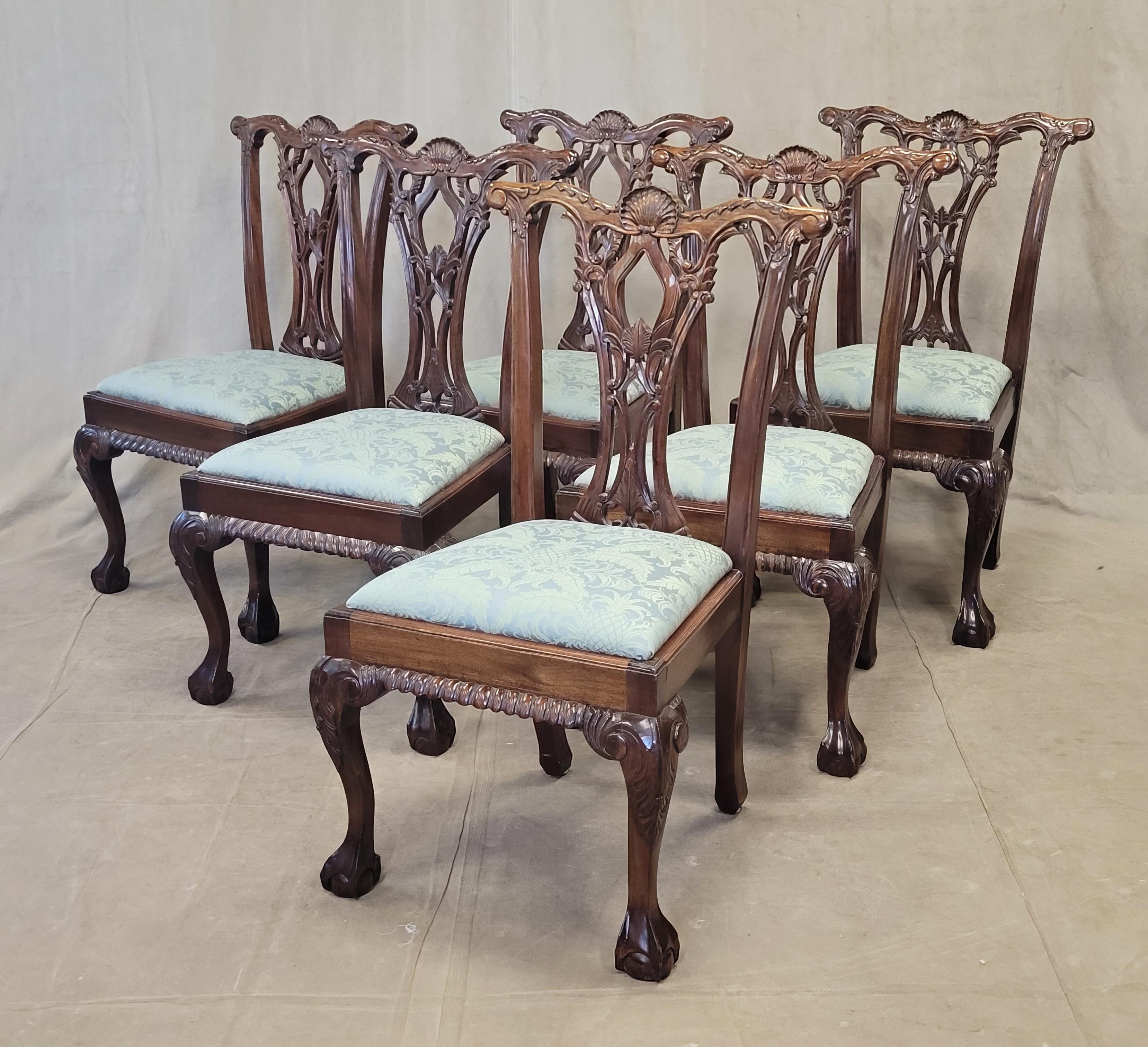 A classic vintage set of six beautifully carved solid mahogany Chippendale style dining chairs. Hand carved details include a shell and leaf motif as well as ball and claw foot. Seats are newly upholstered with a stunning teal (blue/green) silk