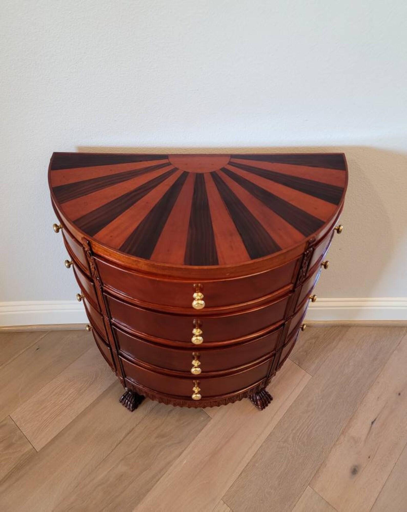 A vintage demilune chest of drawers haberdashery.

Featuring a semi-circular top with wonderfully distinctive radiating sun burst contrasting inlay design, over a very well made conforming bow front case fitted with a most impressive twelve