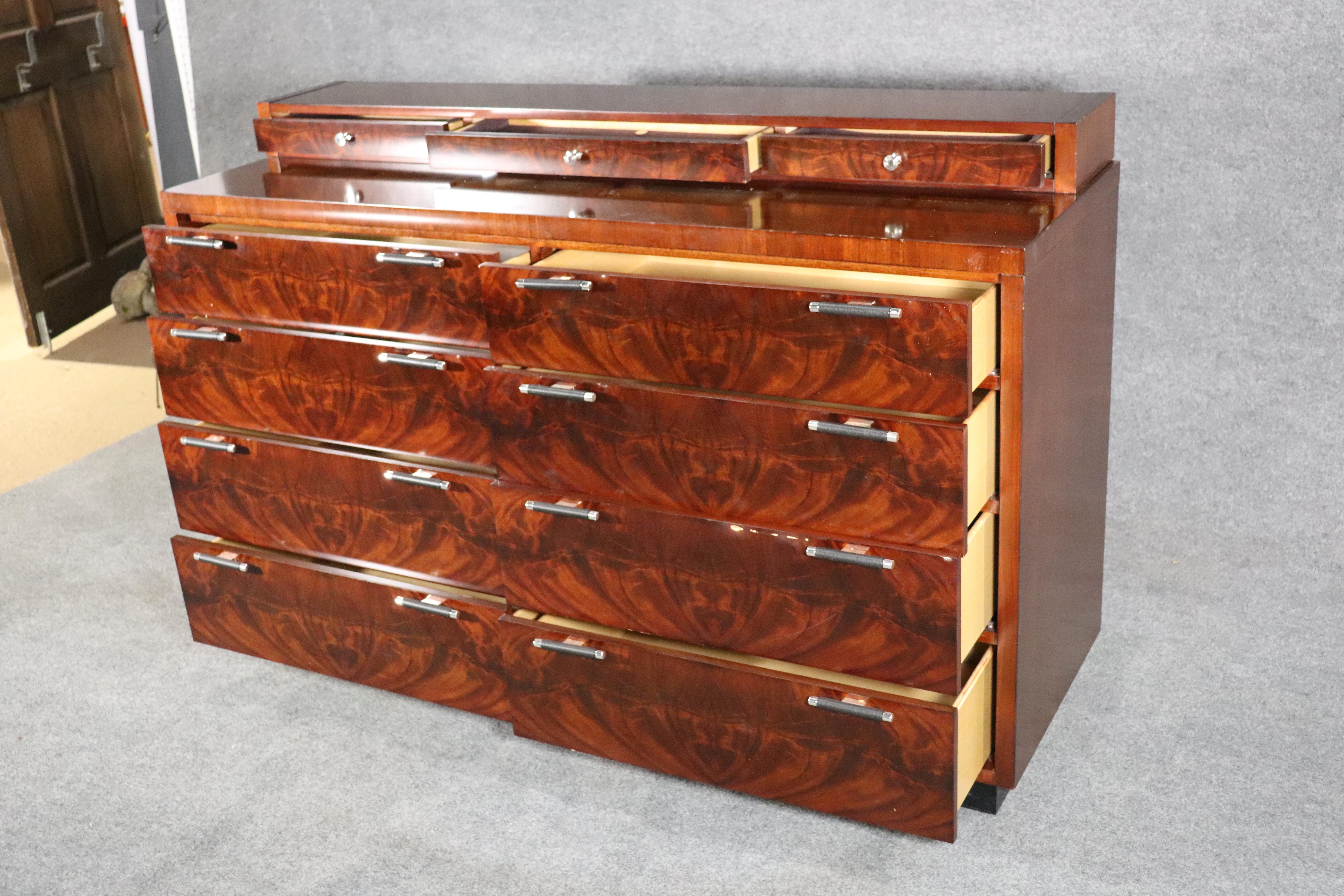 Deco style chest of drawers in rich mahogany with eight wide drawers and three gentleman's drawers on top. Deep grain wood veneer with leather wrapped handles. The drawers interior depth is 15 1/2in.
Please confirm location.