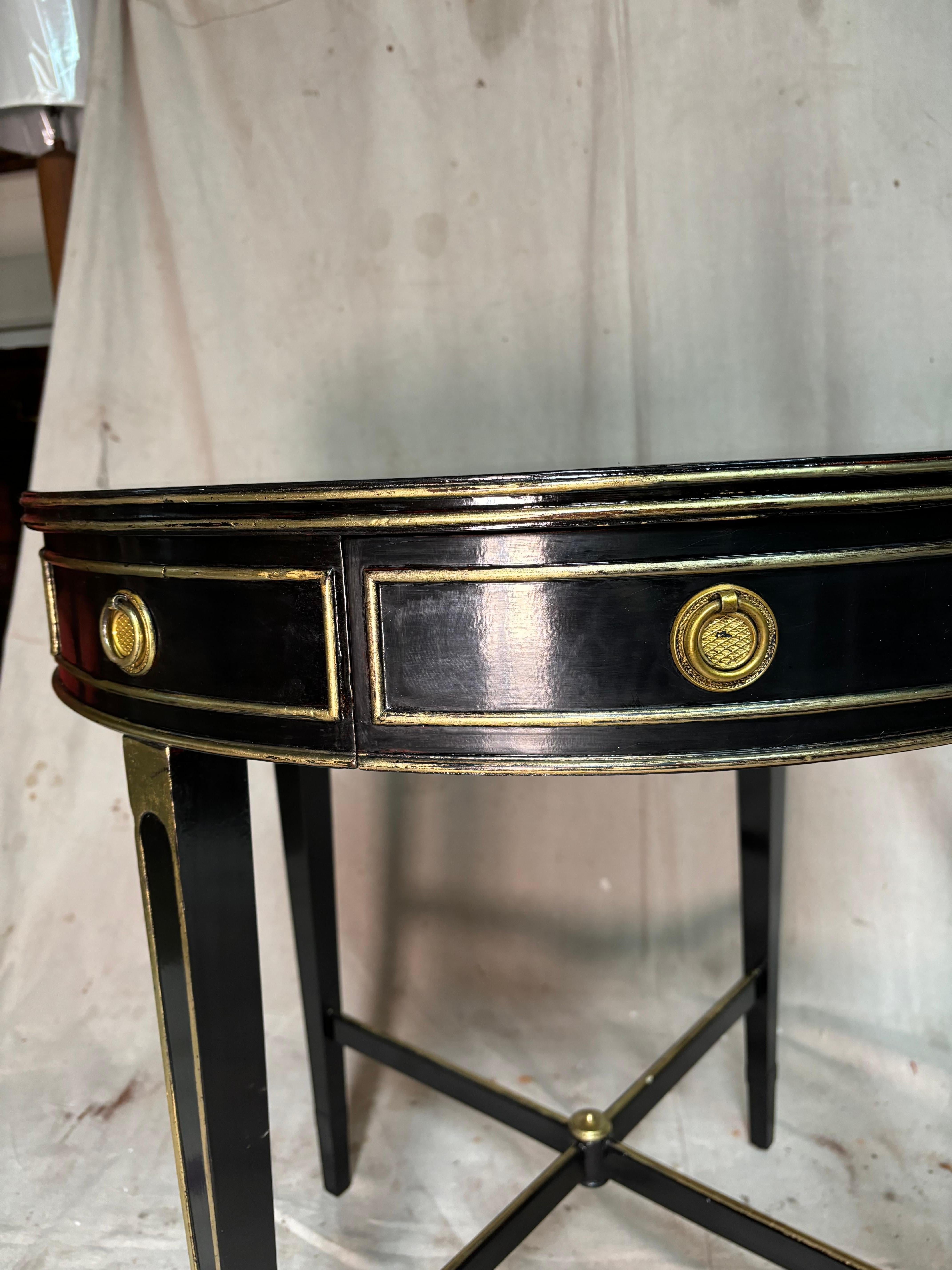 Gueridon table ebonised with lamp black. French polished by hand. Gold leaf applied by hand. 

2 dove tail drawers. 
4 legs tapered with cross streather at bottom.
Hardware Right poll with brass rosettes. 
French polished and waxed.

DE GUSTIBUS NON