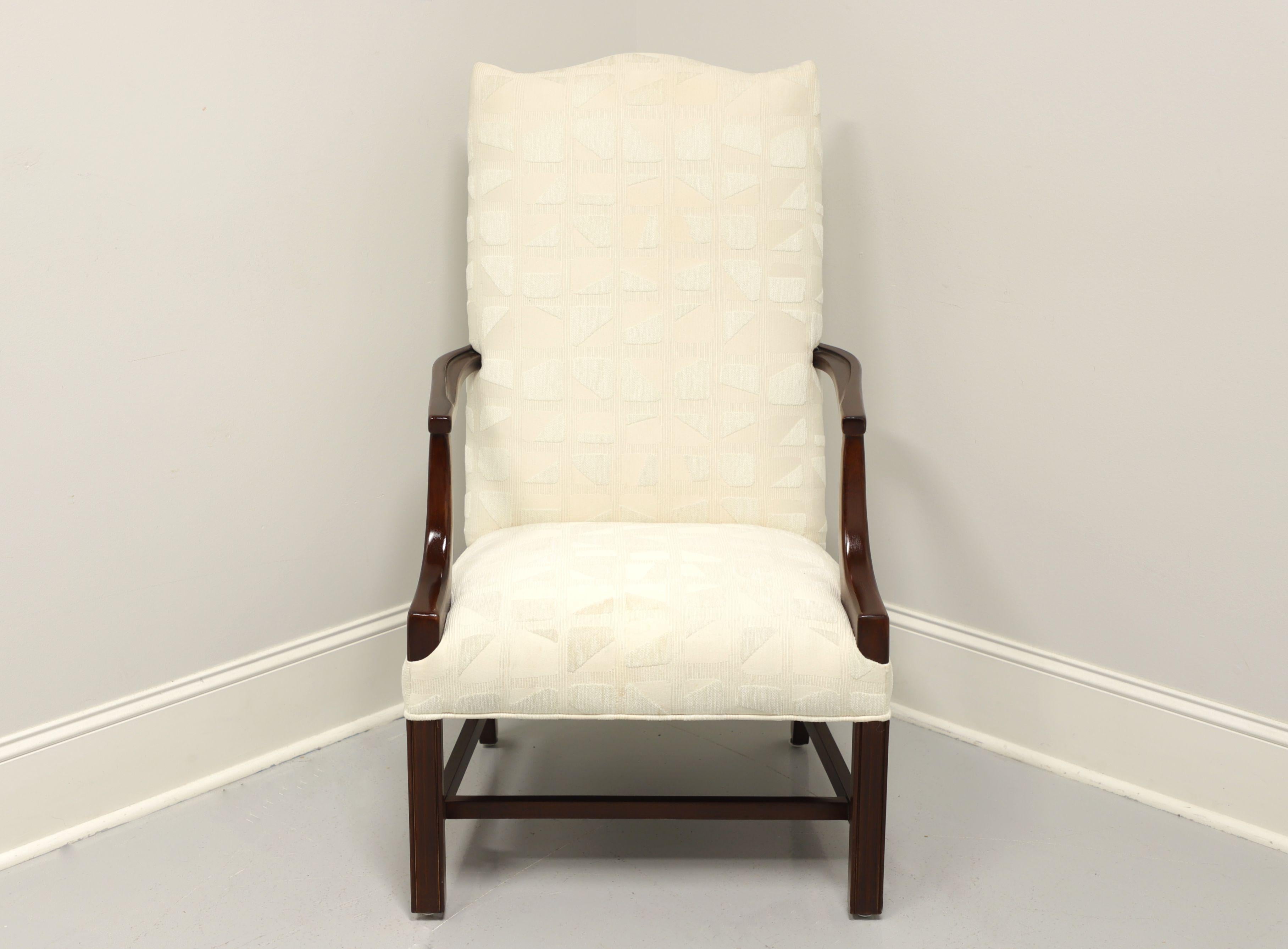 A Chippendale style Martha Washington chair, unbranded, similar quality to Drexel or Hickory chair. Neutral cream colored raised block patteren fabric upholstery on a mahogany frame with straight legs and stretcher base. Made in the USA, in the late