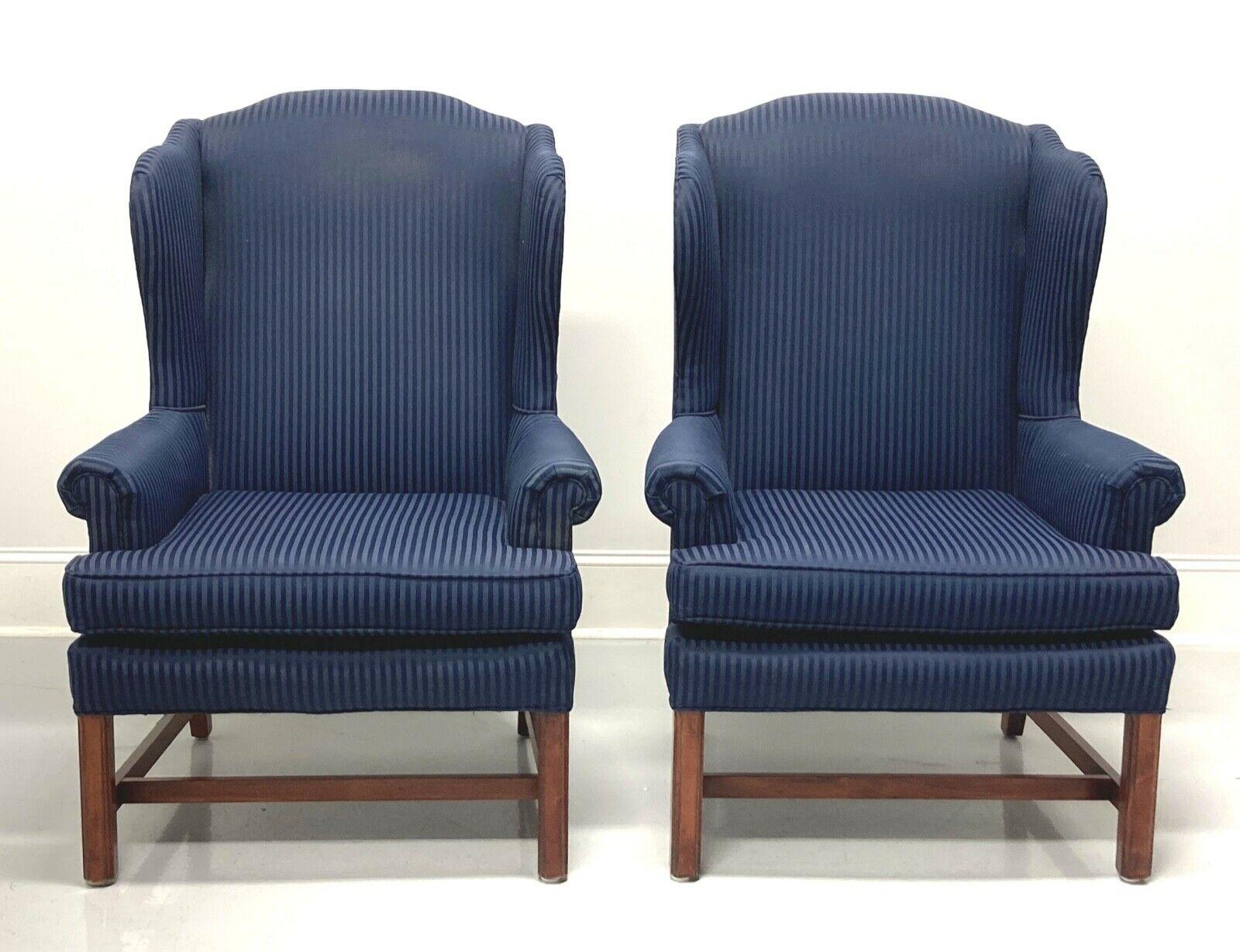 A pair of Chippendale style wing back chairs, unbranded, similar quality to Drexel or Hickory chair. Navy blue damask stripe pattern fabric upholstery on a mahogany frame with straight legs and stretcher base. Made in the USA, in the late 20th