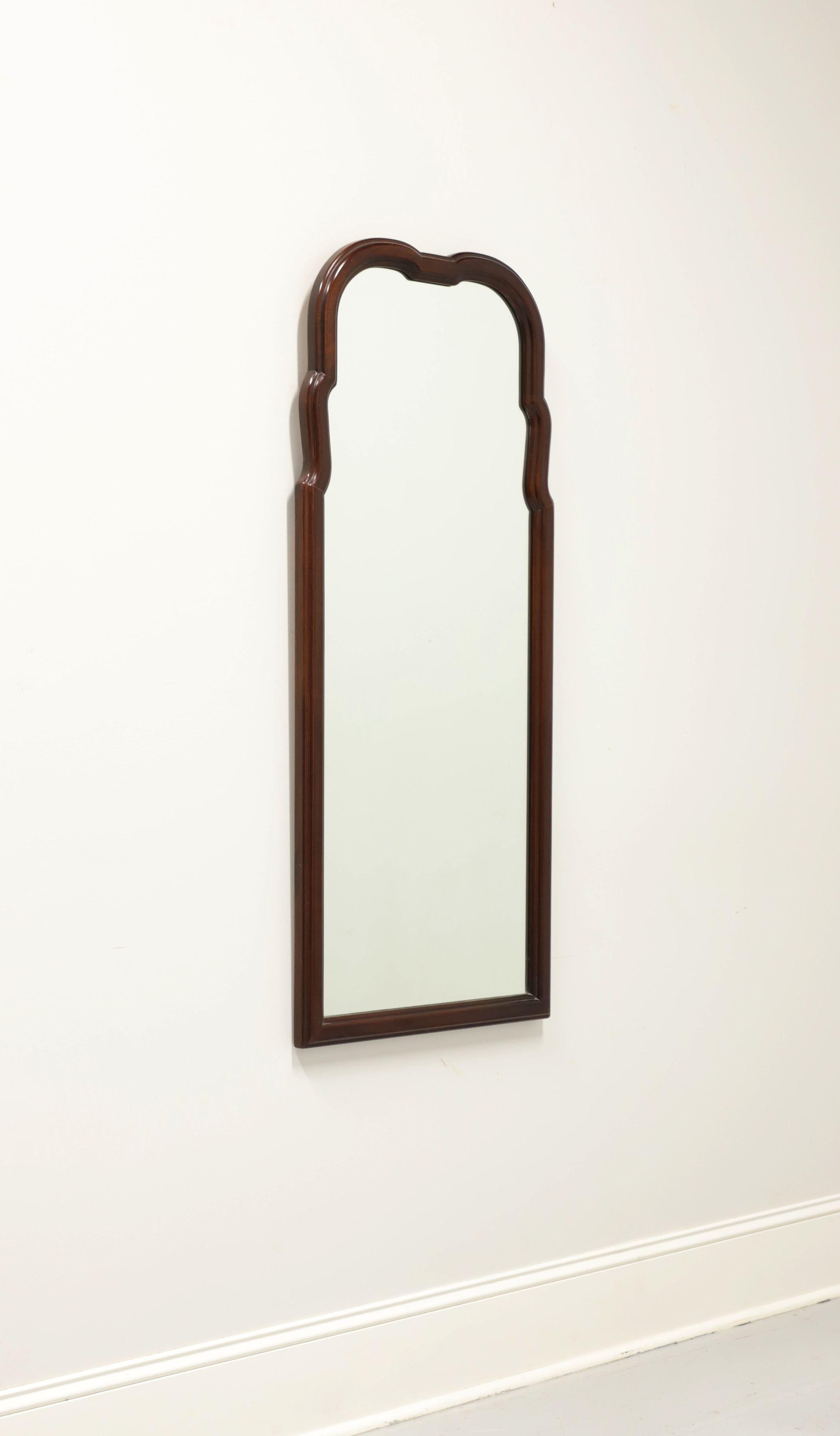 A French style wall mirror, unbranded. Mirror glass and solid mahogany frame with decoratively carved top and slender profile. Made in the USA, in the late 20th Century.

Measures: 20.75 W 1.25 D 48.5 H, Weighs Approximately: 24 lbs

Exceptionally