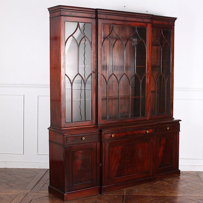 A smaller-scale Georgian-revival breakfront bookcase with upper adjustable shelves behind astragal-glazed doors and lower cabinets with flame mahogany fronts. Three fitted drawers. 

 