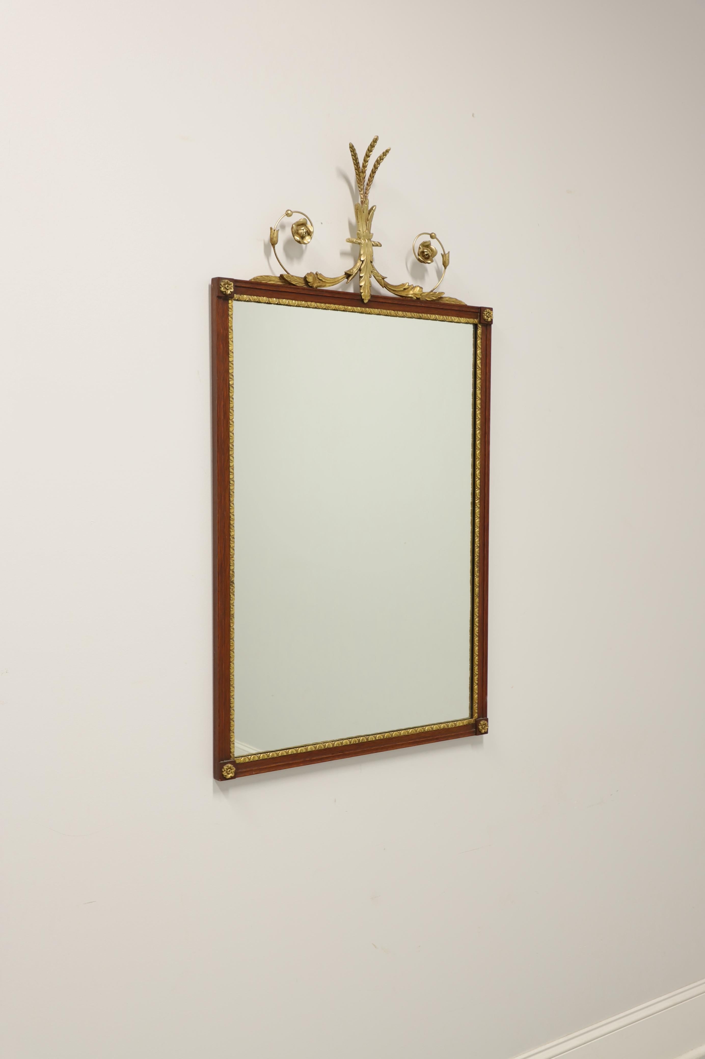 A Neoclassical style wall mirror, unbranded. Mirrored glass in a mahogany frame with gold painted ornamentation. Features an ornate garland with plume to top of frame, gold trim and gold medallions to four corners. Made in USA, in the late 20th
