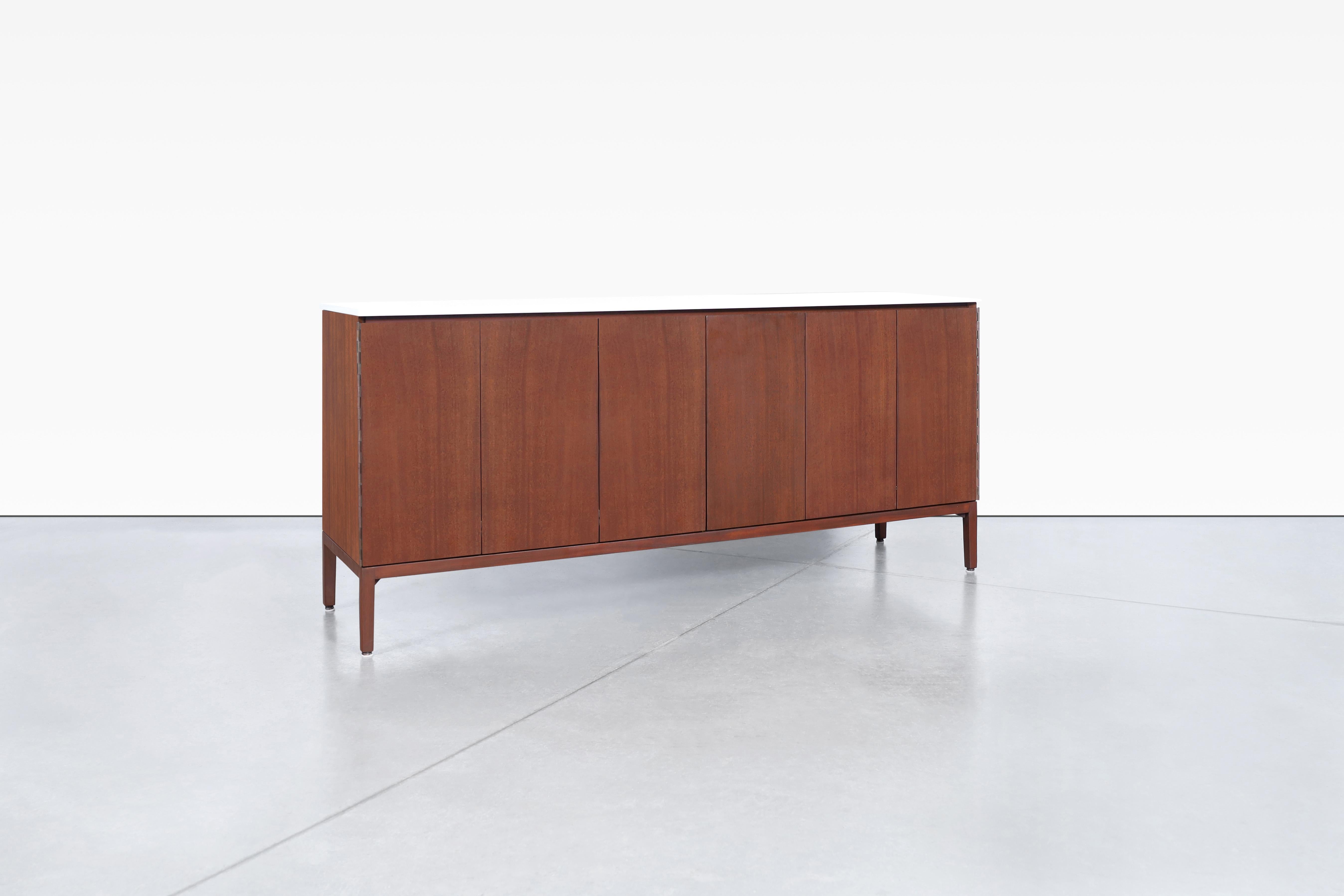 Diese Vintage-Credenza aus Mahagoni ist ein wunderschönes Möbelstück, das von Paul McCobb entworfen und von Calvin Furniture als Teil der Irwin Collection'S hergestellt wurde. Diese Kredenz, die für ihre hochwertigen Stücke bekannt ist, verfügt über