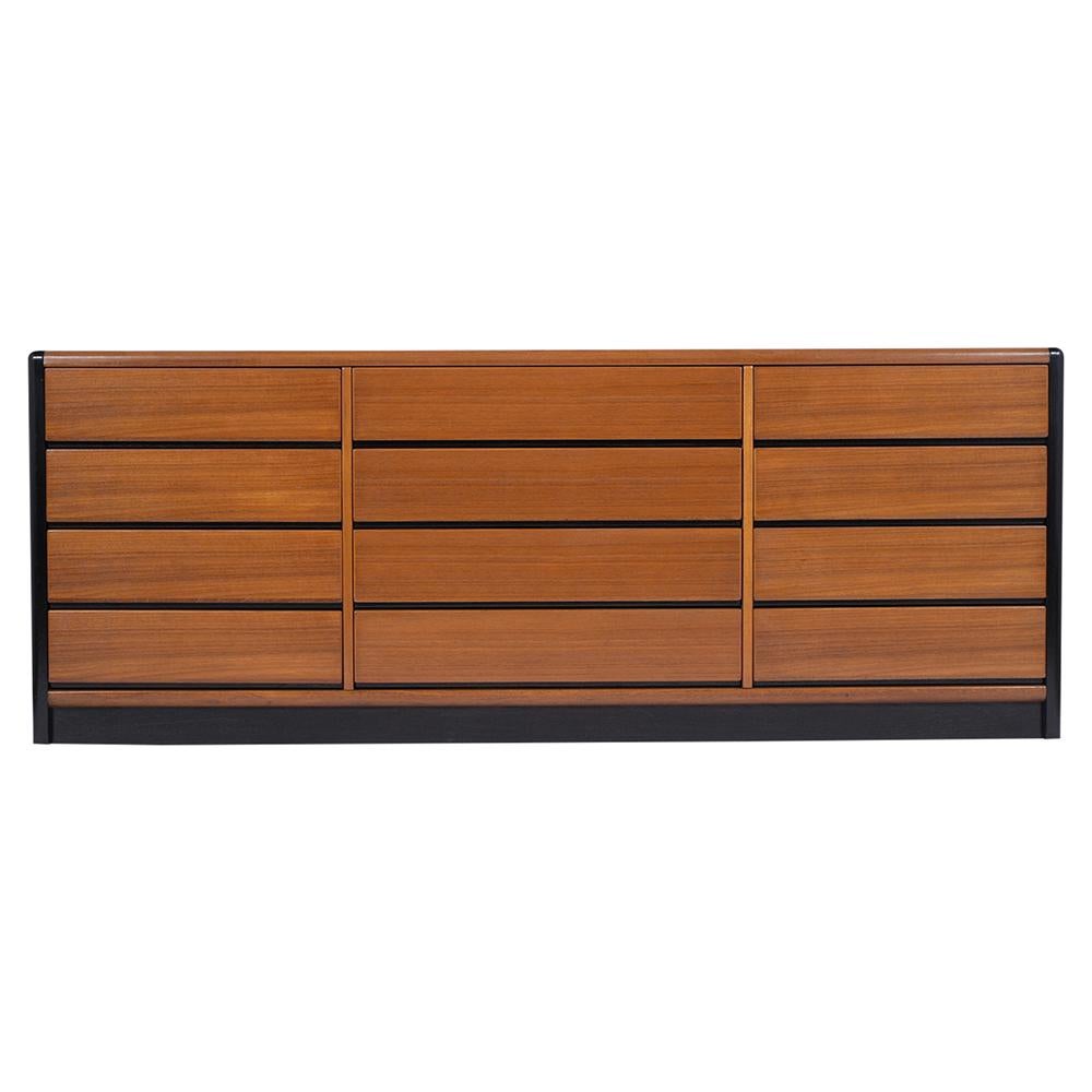 A 1970's Mid-Century Modern credenza that has been fully restored, is made out of mahogany wood stained in a rich black color with a semi-gloss lacquered finish. This fabulous sideboard features twelve pull-out drawers, all the drawers come with