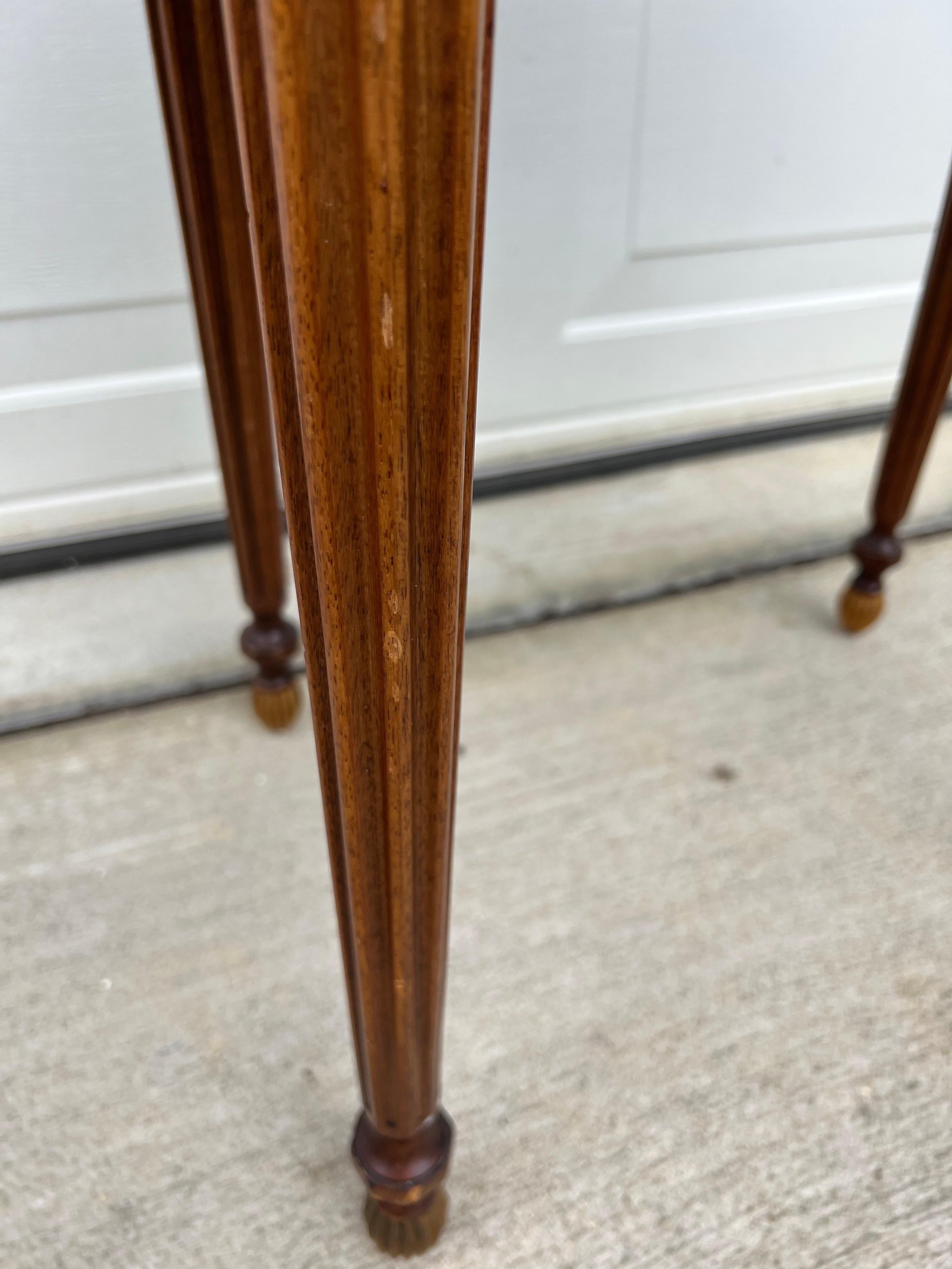 Exquisite Baker Mahogany Oval Side Table with Shaped Brass Gallery, Fluted Apron, on Fluted Tapered Legs. Table has a glass