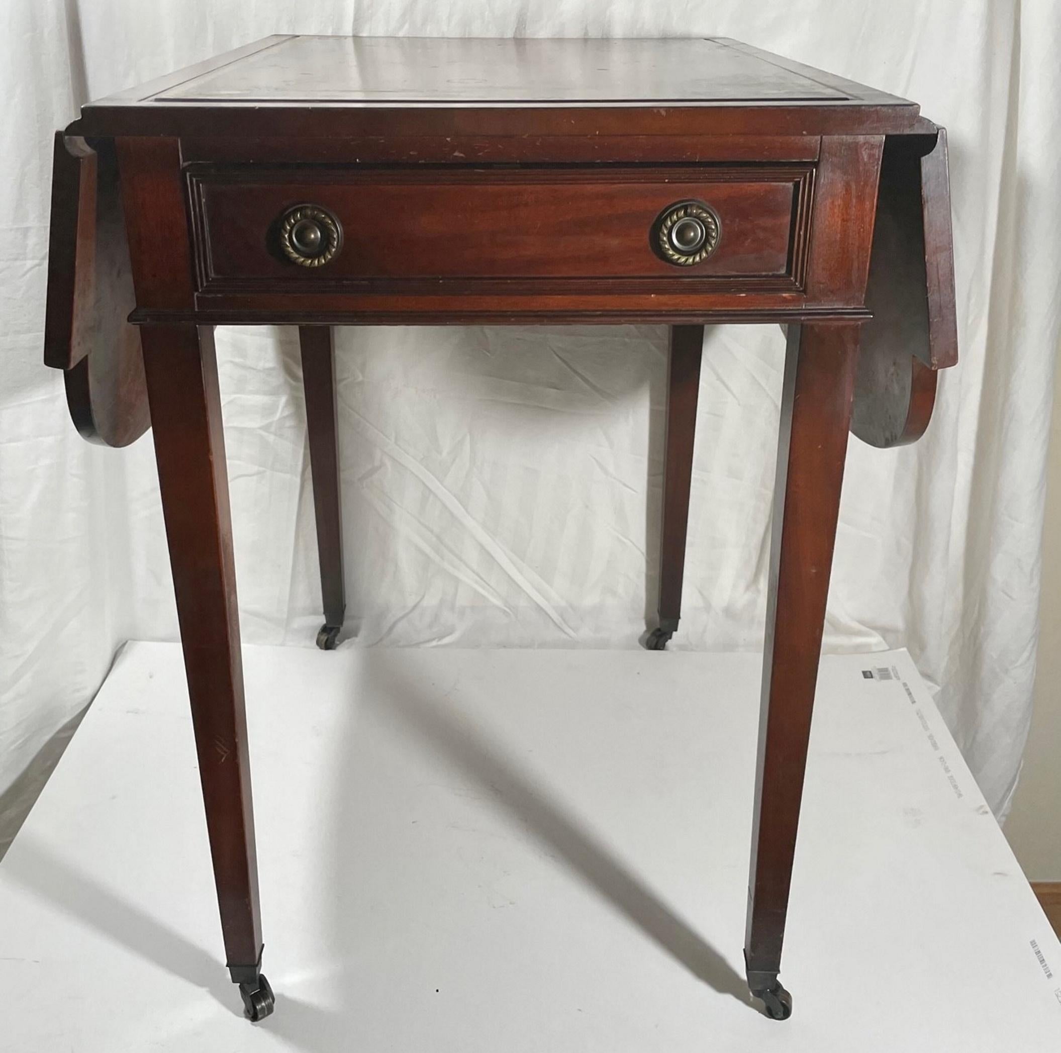 Vintage Mahogany Pembroke table, Gordon’s Fine Furniture, Inc.

A Classic Pembroke table by Gordon’s Fine Furniture, Inc. made of mahogany with tooled leather writing surface. Single drawer to one side with brass pulls. Flaps on either side that