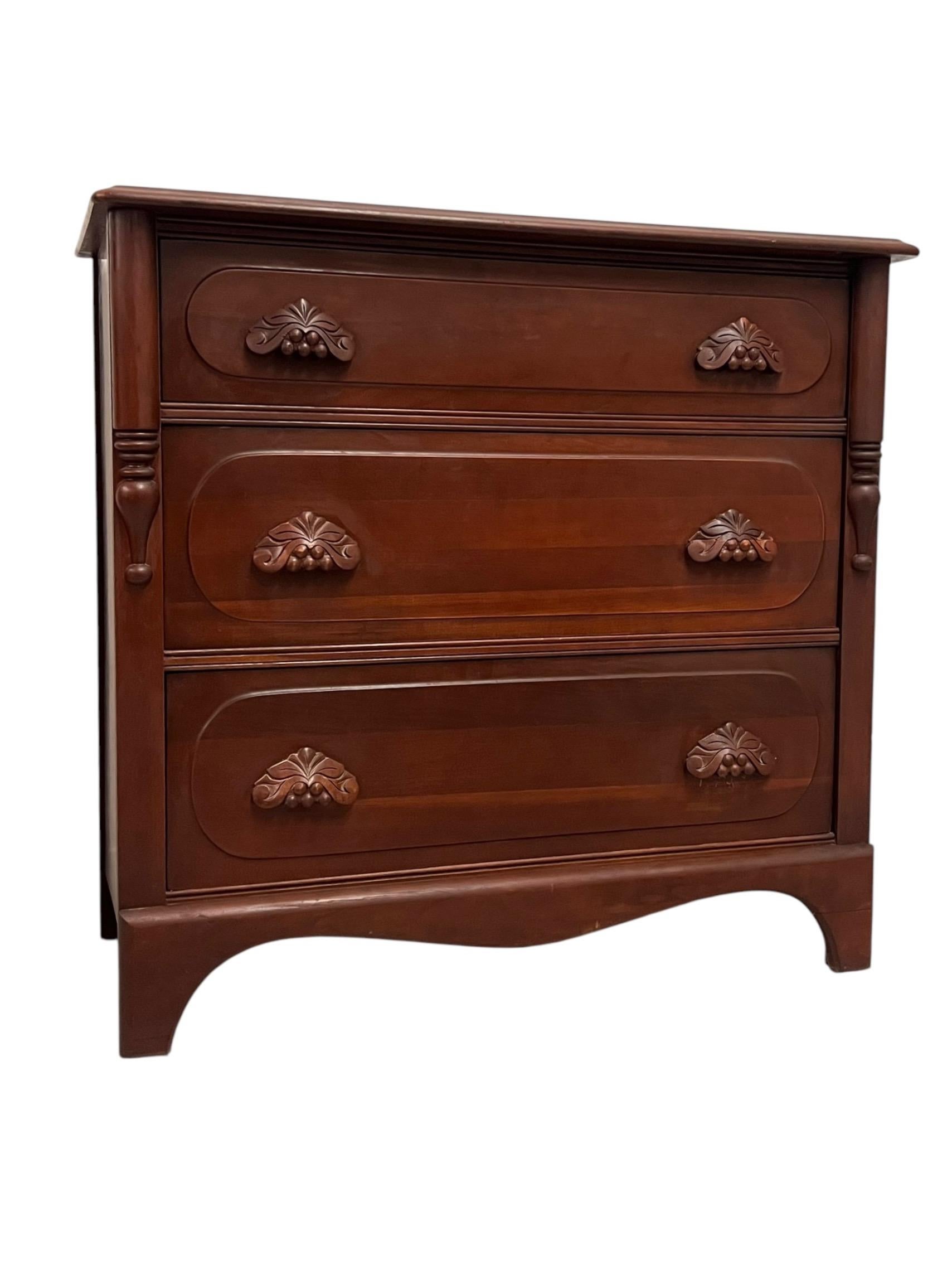 Esta cómoda vintage de madera de caoba presenta un elegante diseño con tres cajones de cola de milano, que muestra la artesanía de su época. La cómoda se caracteriza por su rico acabado en caoba, que resalta la belleza natural de la madera. Cada