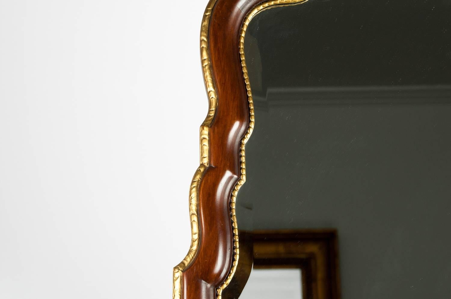 Vintage French style mahogany wood framed hanging wall mirror. The hanging mirror is in excellent vintage condition. The mirror measure about 59 inches long x 23.5 inches width.