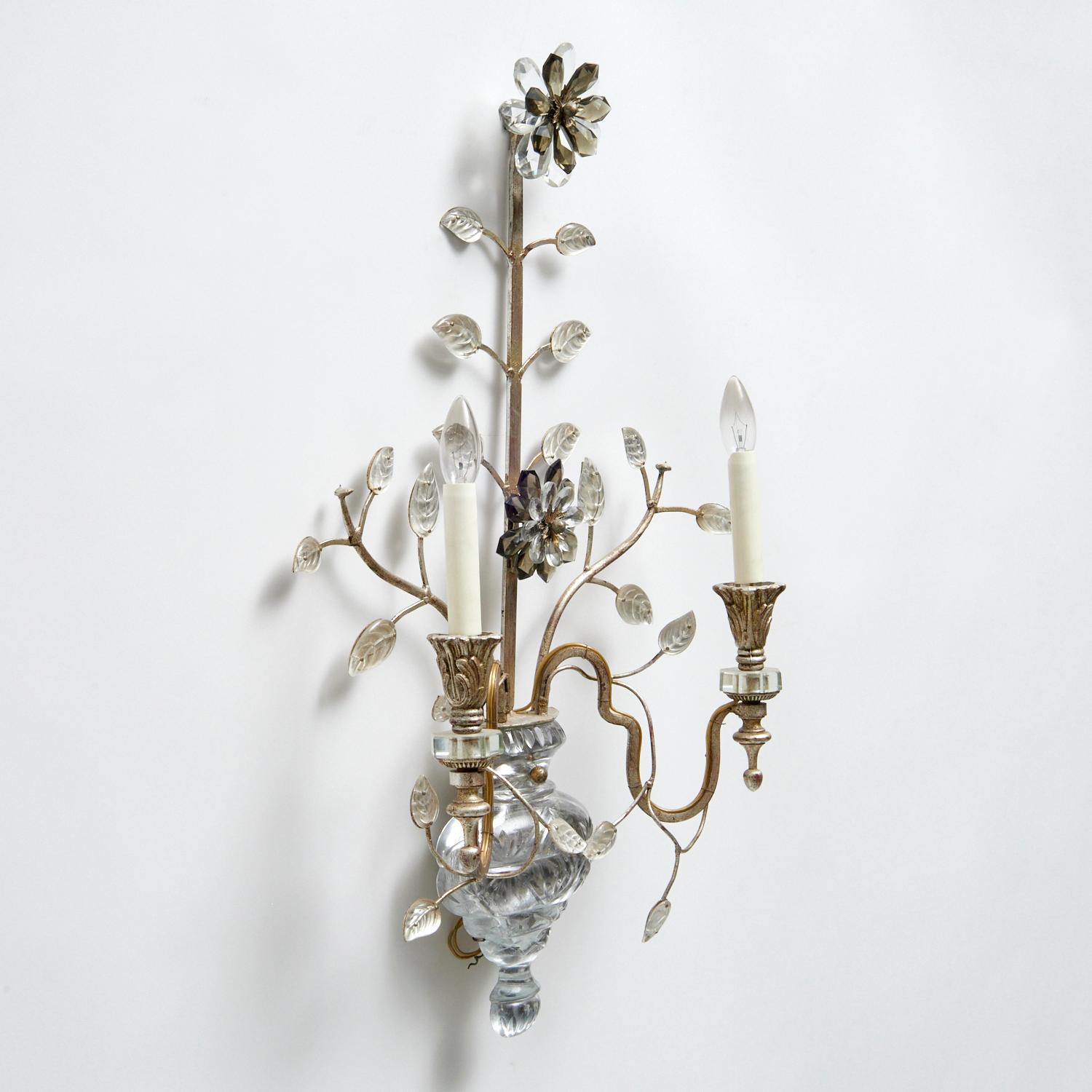 Vintage 20th c., France, attributed to Maison Baguès, a large yet delicate wall sconce. A cut crystal backplate modeled as a vase issuing a tall flower stalk with multiple leaves and cut crystal flower heads, supporting two scroll arms topped with