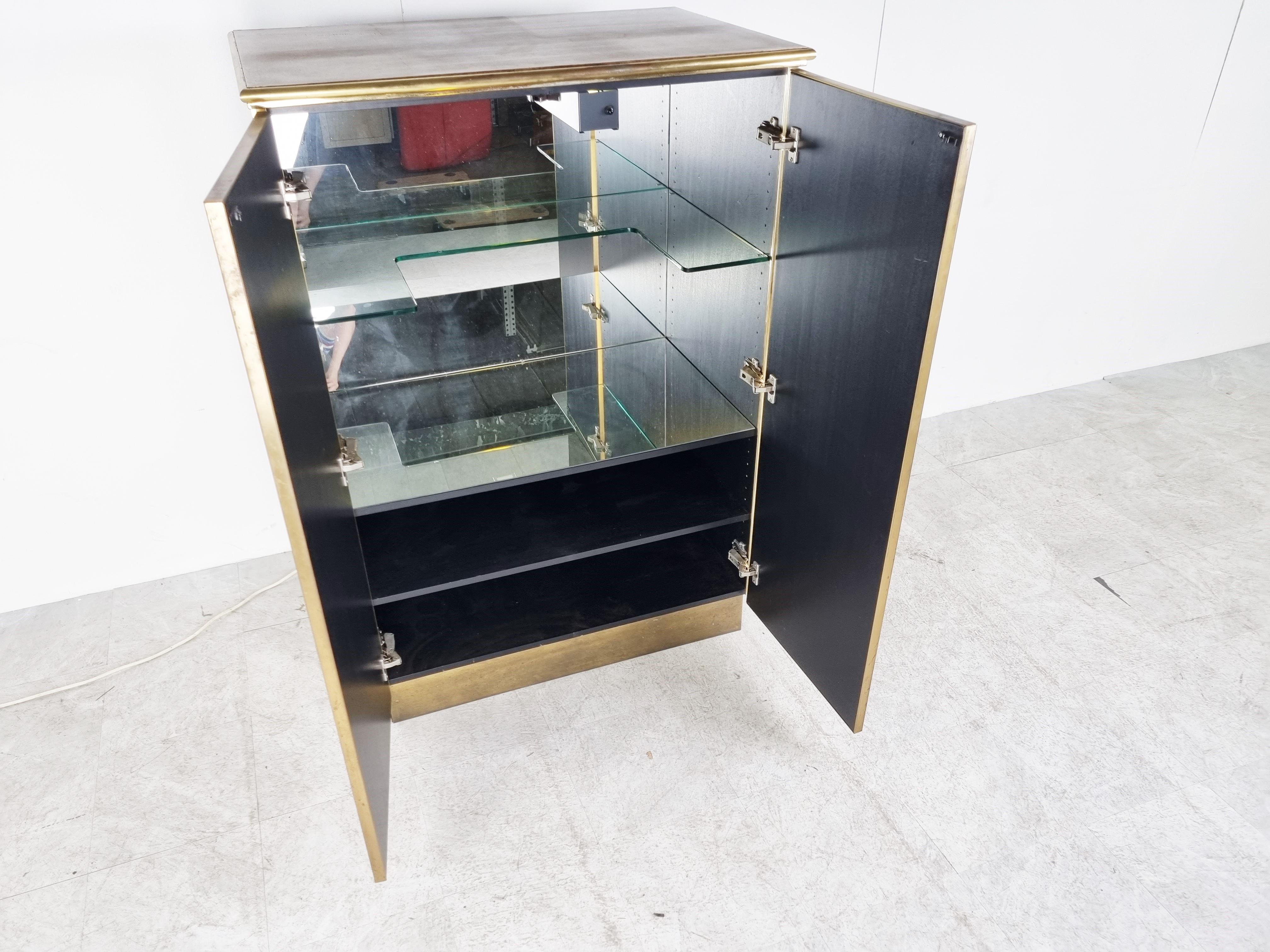 Beautiful brass bar cabinet by Maison Jansen.

The cabinet is made from beautiful brass panels and mirrored side panels with a glass and mirror shelving inside.

Good condition with beautiful aged look.

1980s - France

Dimensions:
Height: