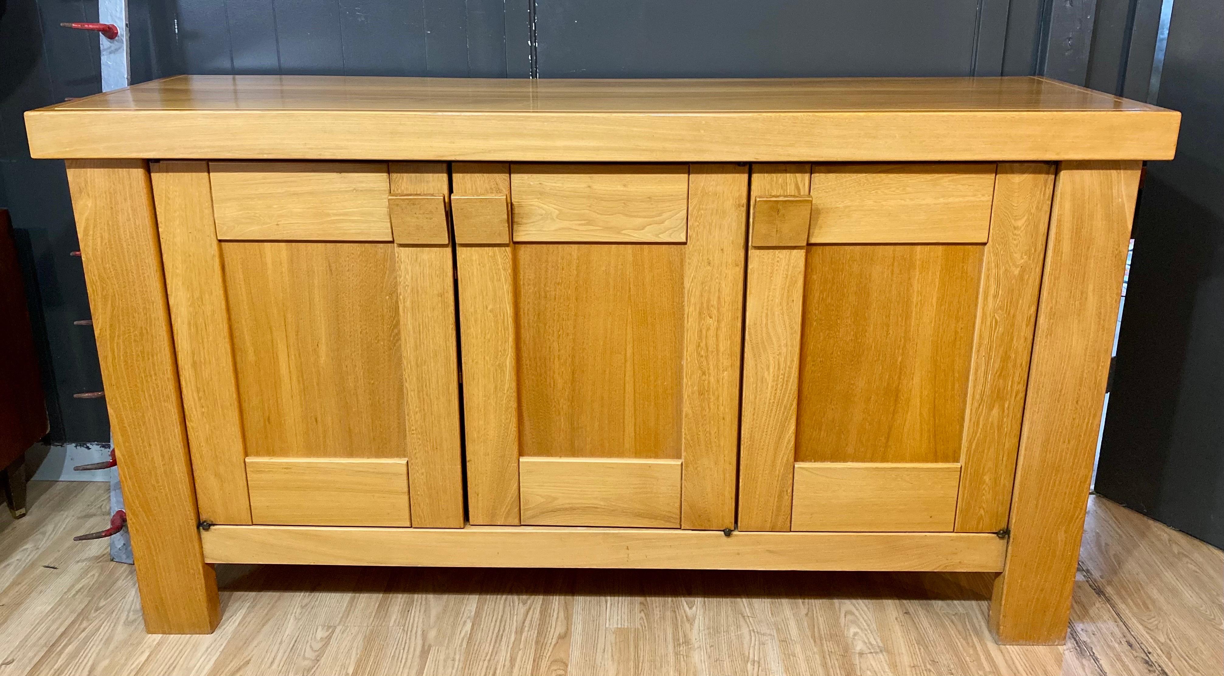 Vintage brutalist Maison Regain sideboard made of solid elm, circa 1970s, France. This vintage credenza features a total of three doors with pulls. The two pulls on the left open up to three shelves and pull on the right opens up to a drawer and two