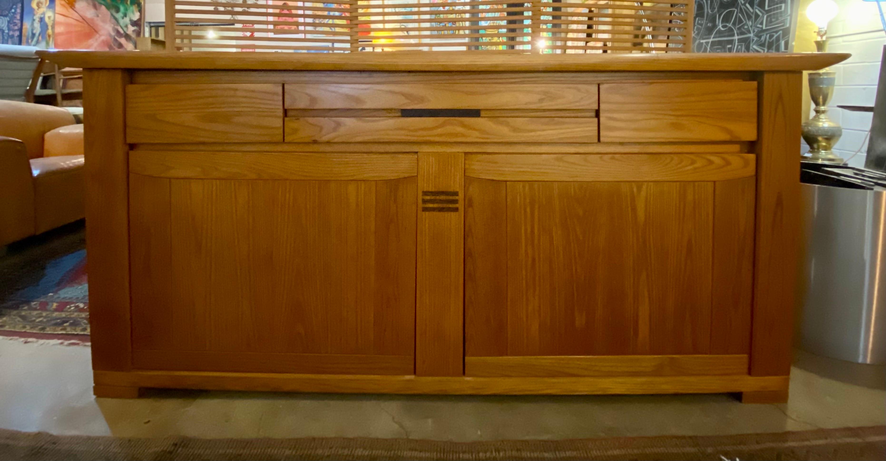 Vintage brutalist Maison Regain sideboard made of solid elm, circa 1970s, France. This vintage credenza features three drawers at the top and two divided compartments on each lower half. This piece is sturdy and in good overall condition. The back