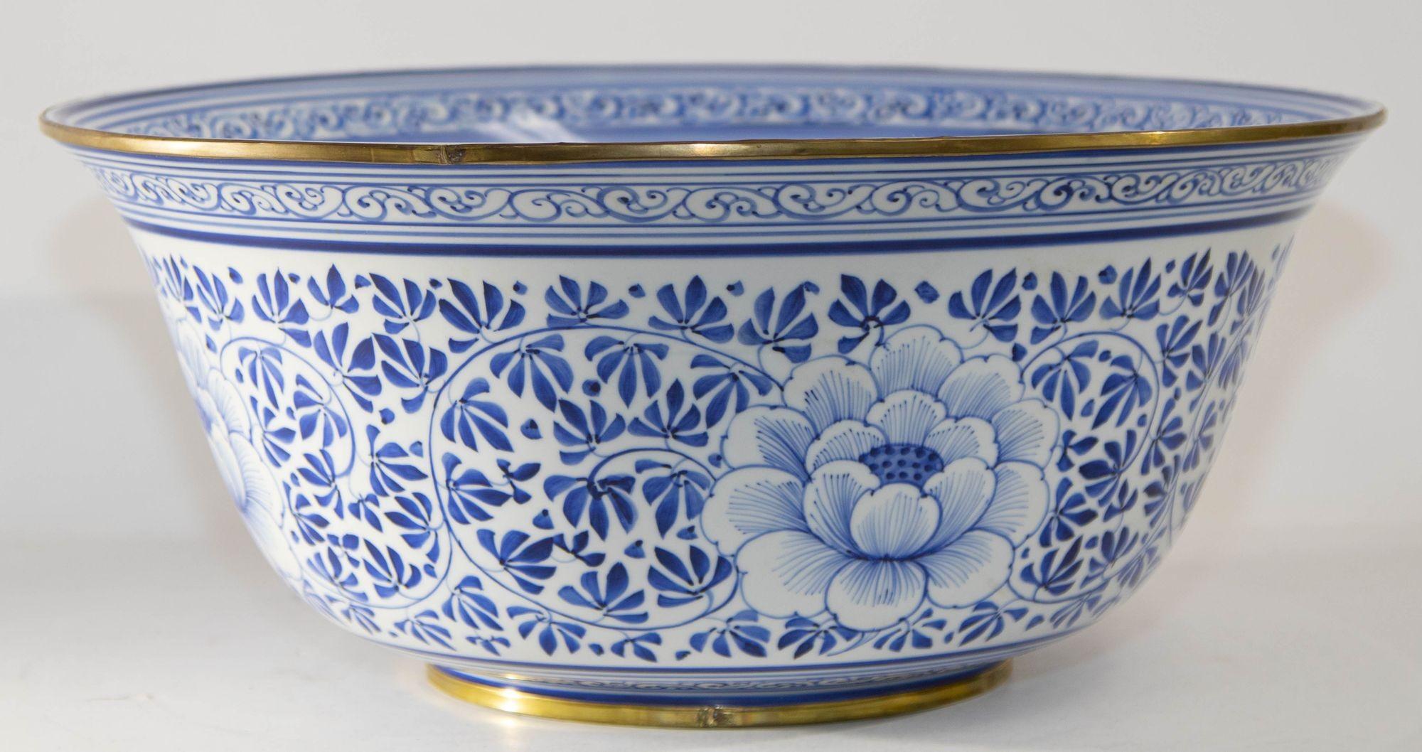 Vintage Maitland Smith large decorative blue and white porcelain bowl with brass rim.
Thai Hand-painted porcelain bowl with floral motifs, blue and white with brass rings running the circumference of the bottom and the top. Vintage Maitland Smith