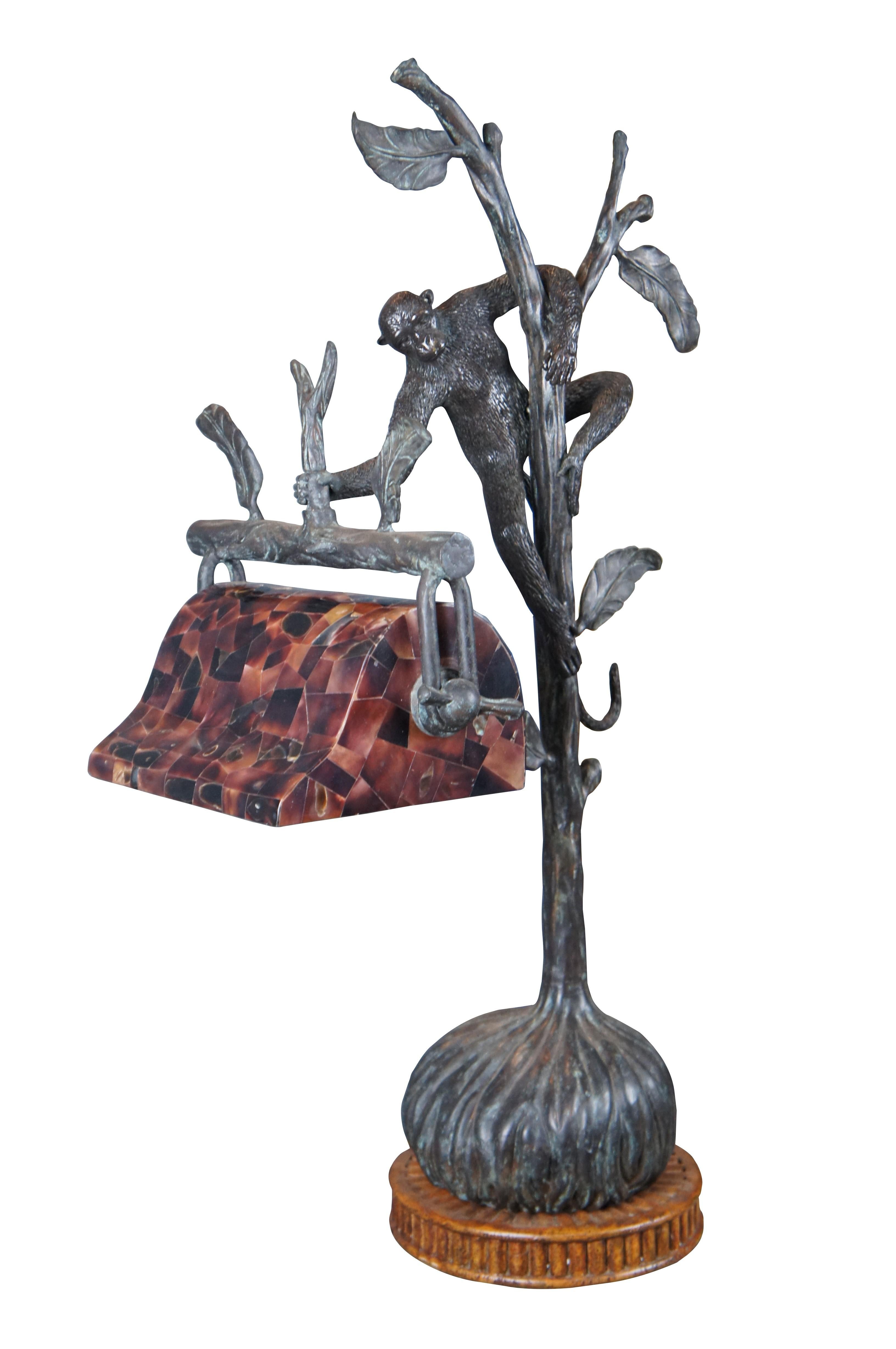 An impressive handmade figural bronze lamp by Maitland Smith. Features a monkey climbing a tree branch, holding an adjustable banker style pen shell shade. The bronze is mounted to a round wooden fluted base. Marked along underside.

Dimensions:
27