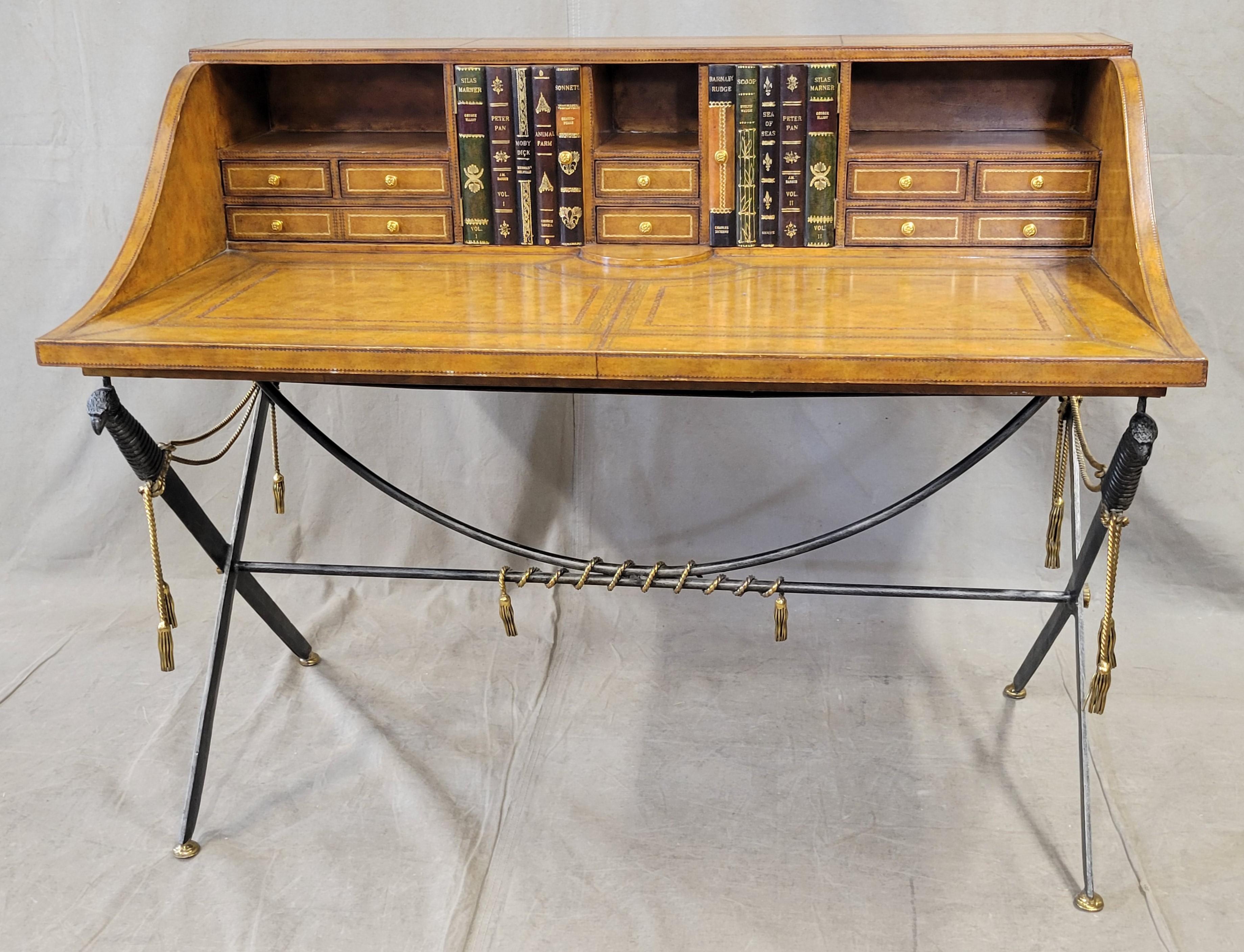 What a unique statement piece! This vintage Maitland-Smith British campaign desk is made of gold embossed leather covered wood. In the gallery portion of the desk are eight drawers and five cubbies, two of which are concealed with charming faux book